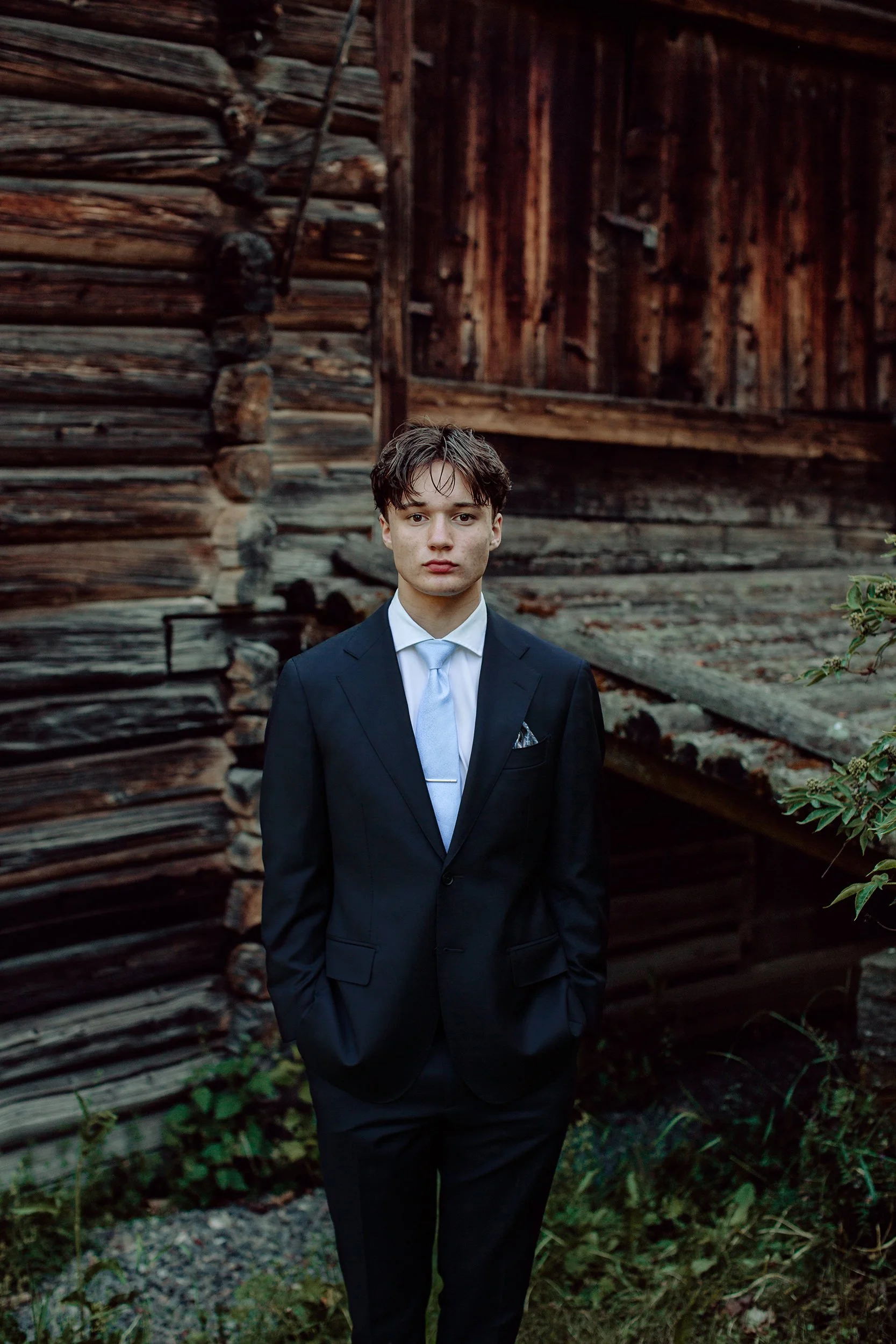 Konfirmantfotografering. Konfirmant I dress foran låve