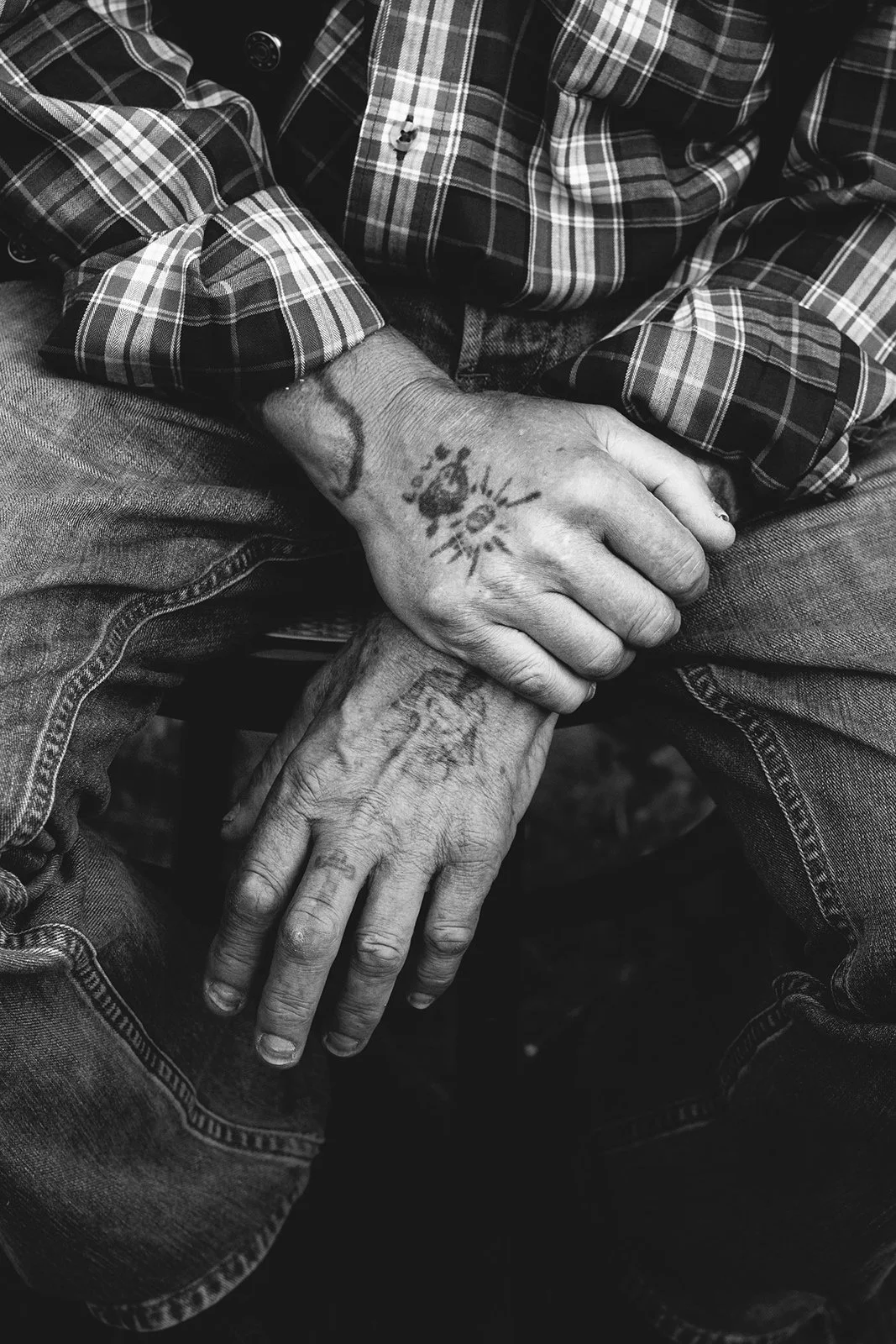 Nærbilde av eldre hender med seilertatoveringer.