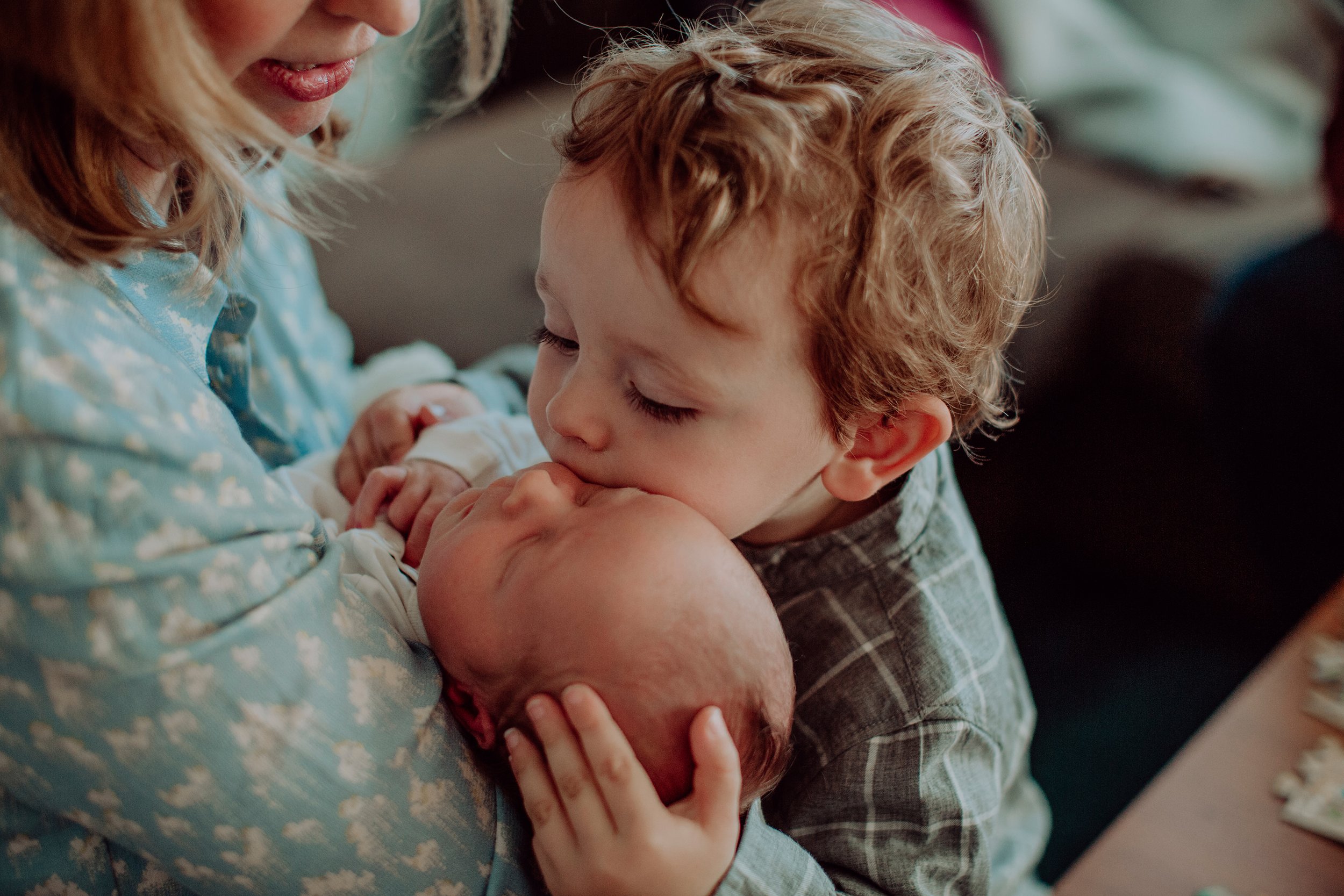Nyfødtfotografering i hjemmet. Storebror gir lillebror en kos.
