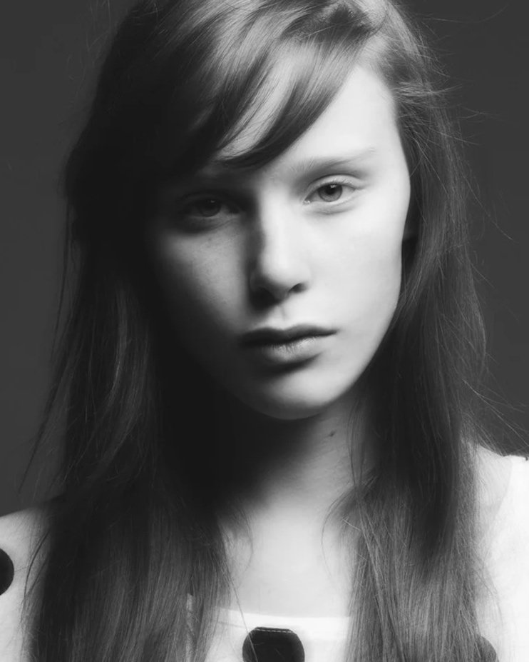 Portrettfotografi av ung jente som ser alvorlig inn i kamera.