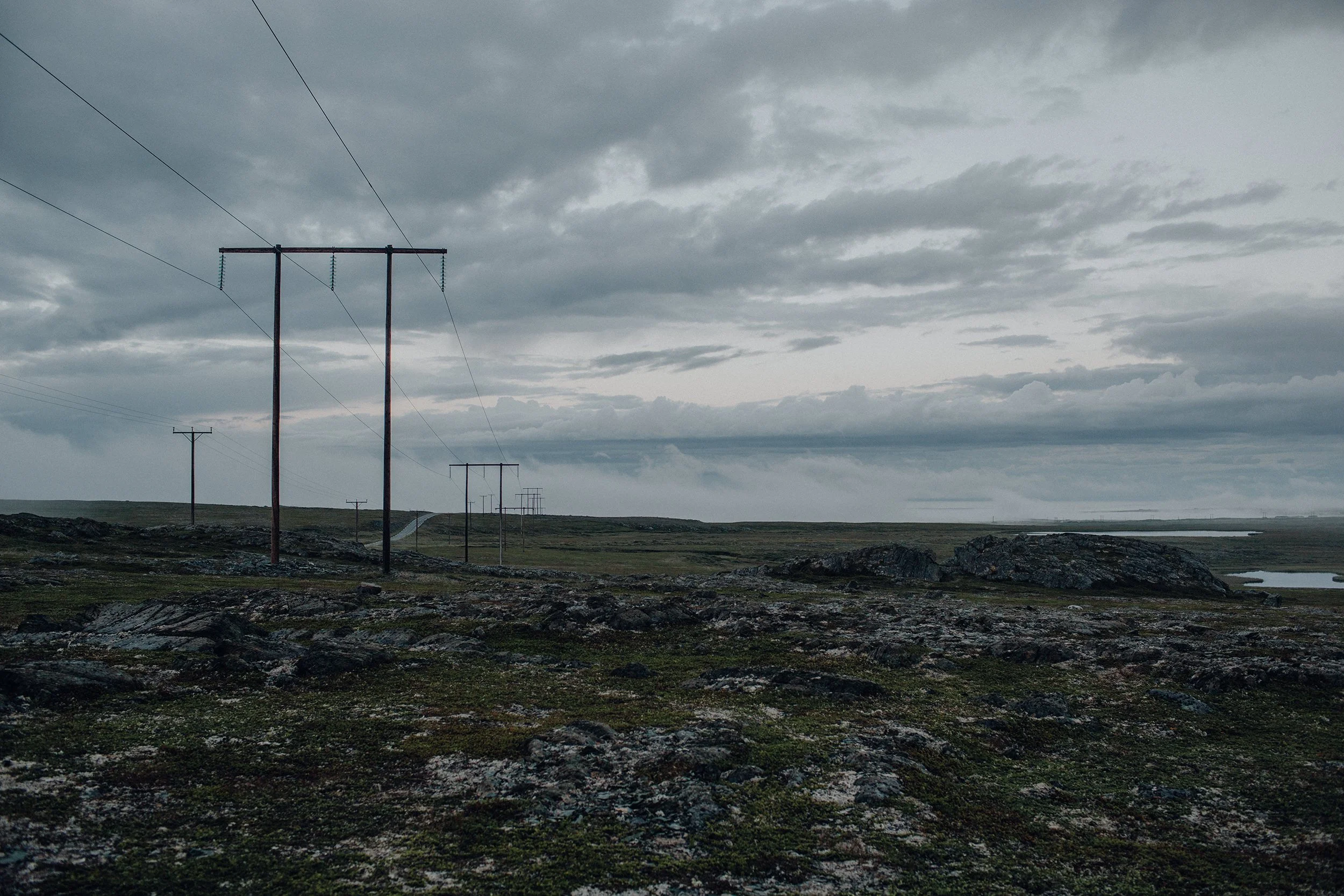 Strømmaster som strekker seg gjennom åpent landskap på Varangerhalvøya.