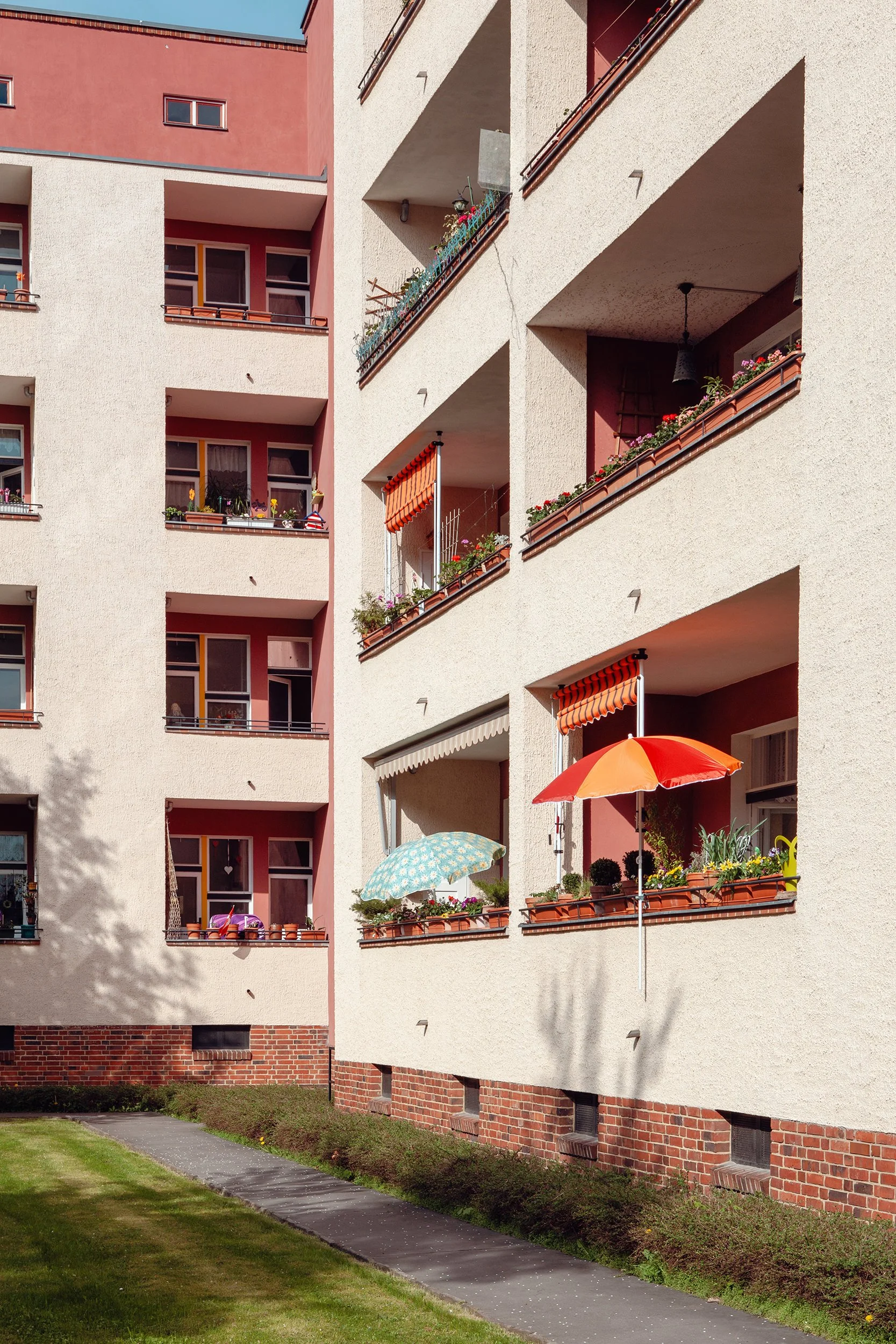 Boligblokk med terasser og parasoller i glade farger i Berlin.