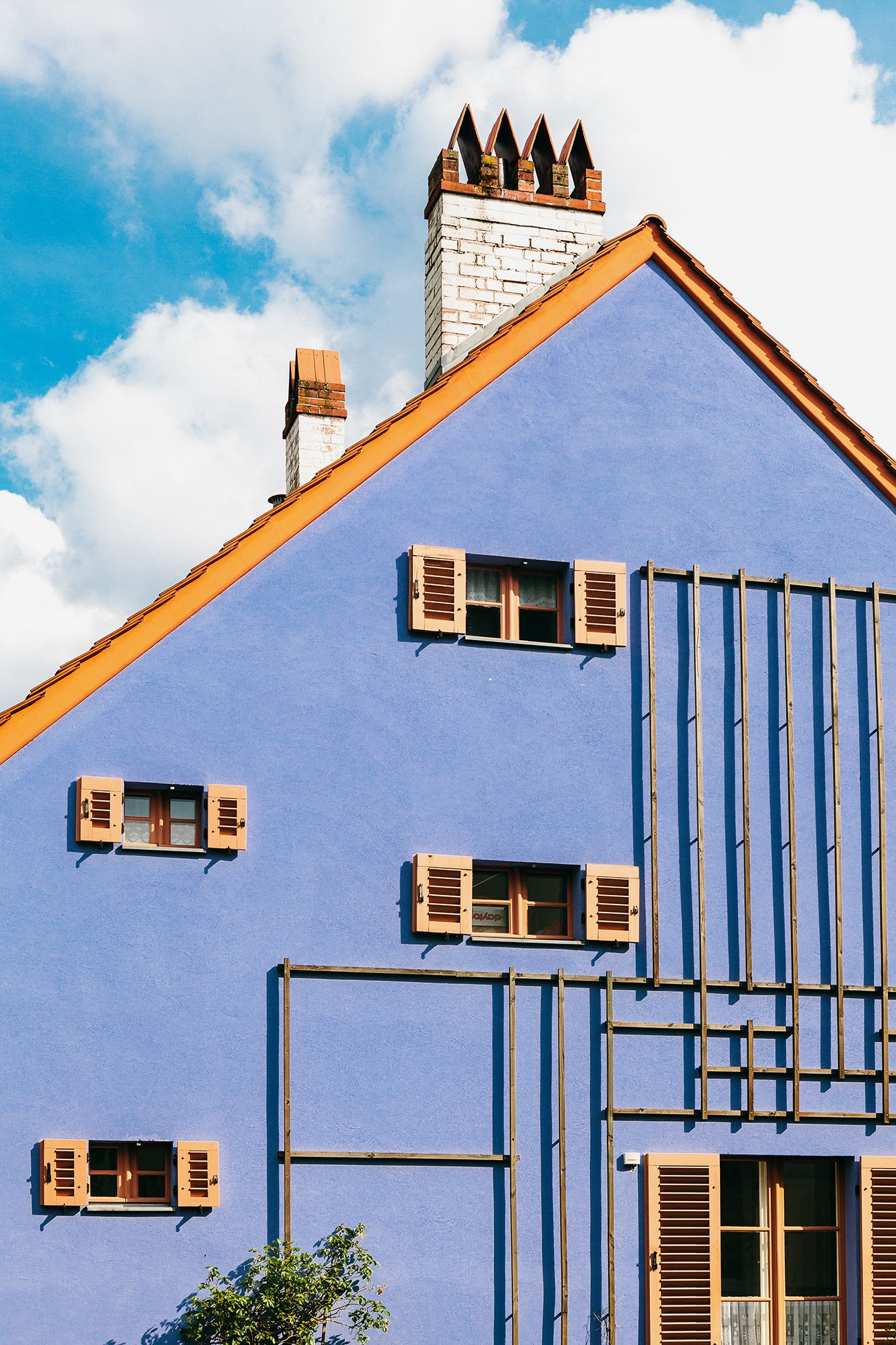 Boligfelt i Gartenstadt Falkenberg i Berlin, tegnet av arkitekt Bruno Taut. Knall blått hus med orange detaljer på vinduer og tak.