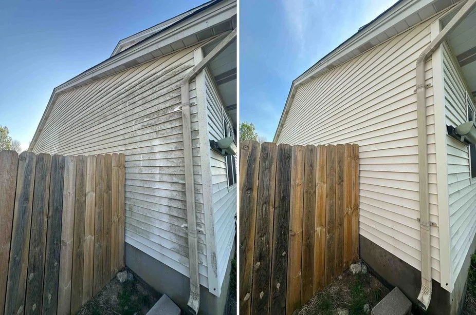 Side-by-side comparison of house siding before and after cleaning. Left side shows dirty, stained beige siding; right side shows clean, bright siding. A wooden fence is in the foreground, and a gutter and downspout are visible.