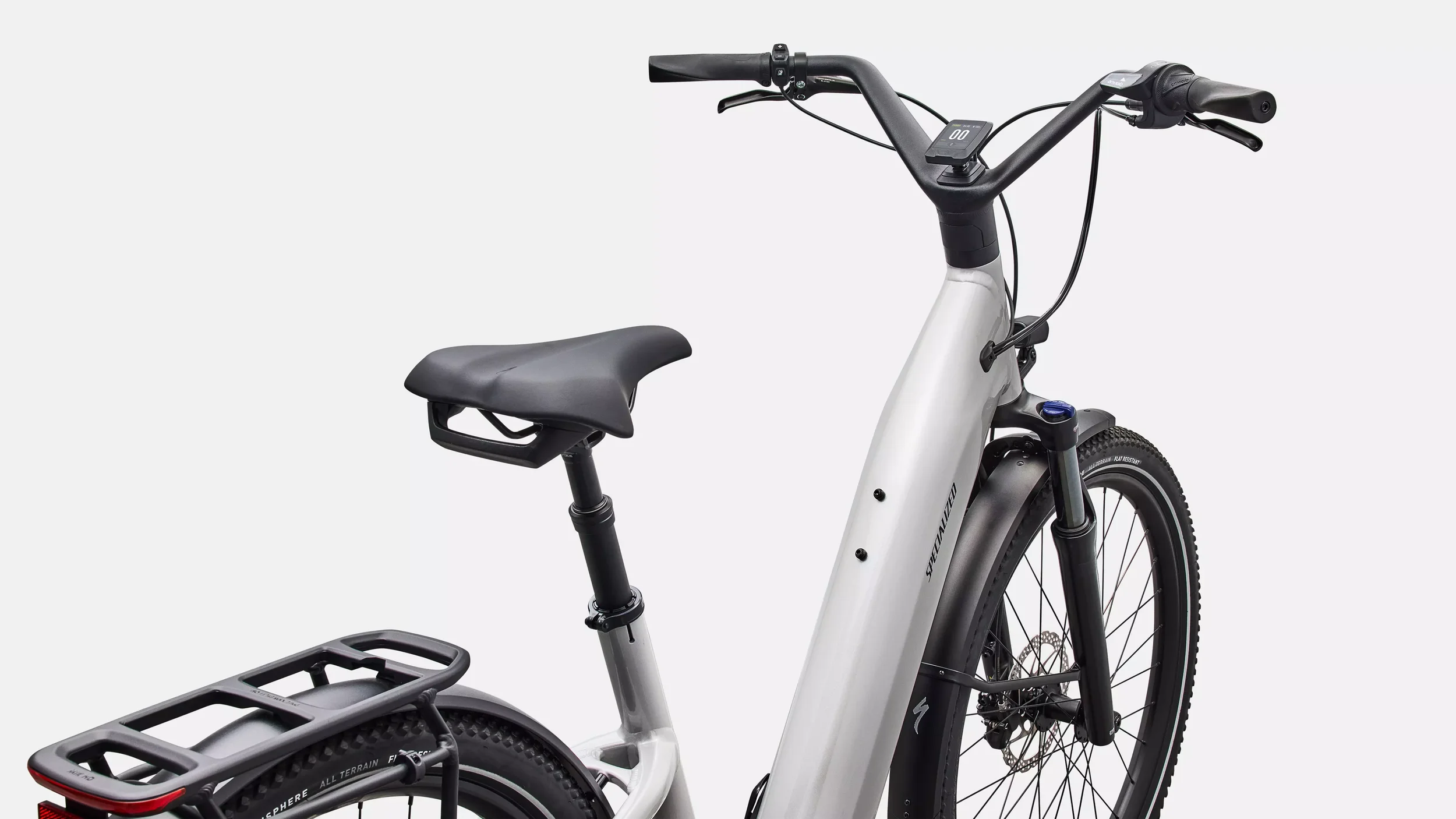 Een elektrische Specialized fiets met grote wielen, een zwart zadel, stuur, en aanhangwagenrek, tegen een witte achtergrond.