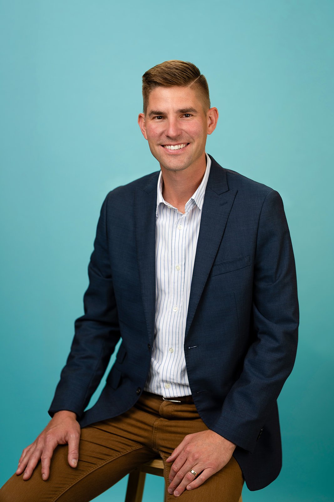 photo of a young man smiling for a studio headshot
