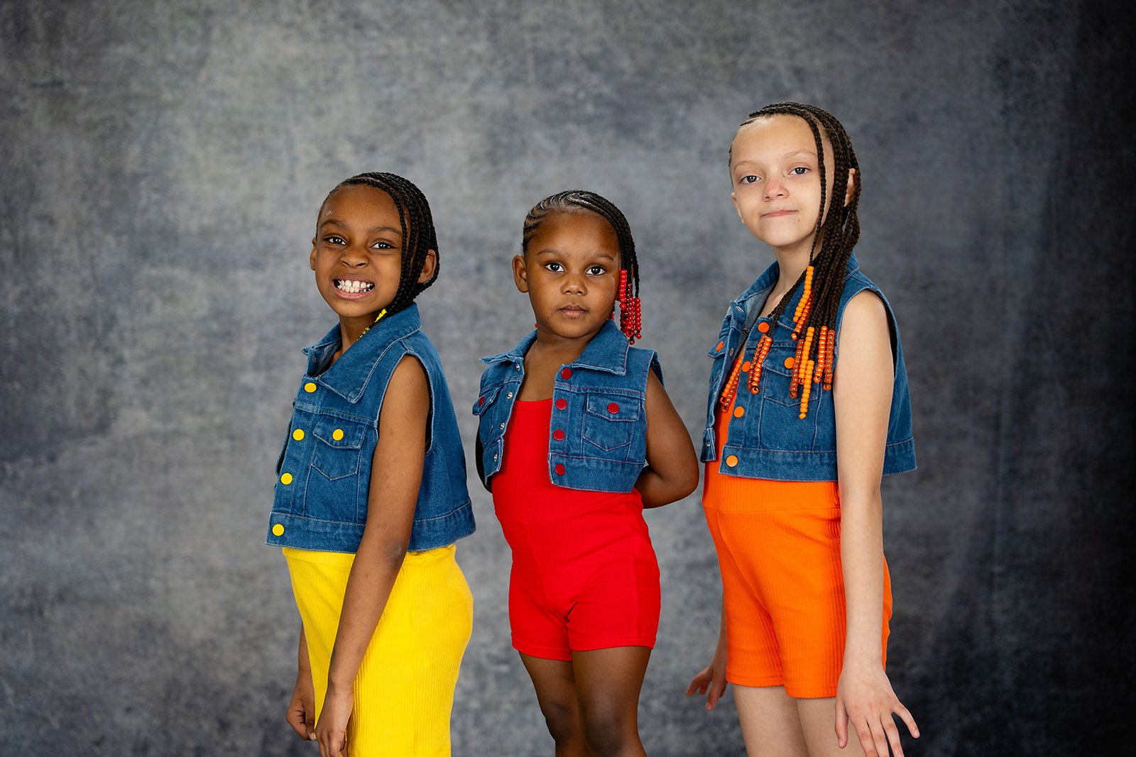 three girls pose together for a studio portrait