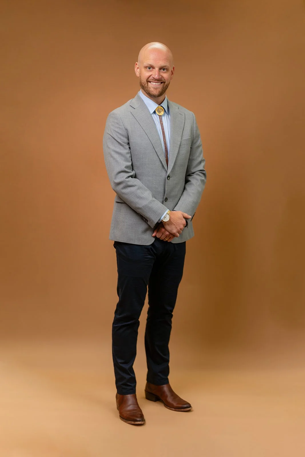 photo of a young businessman smiling for a portrait with his bolo tie