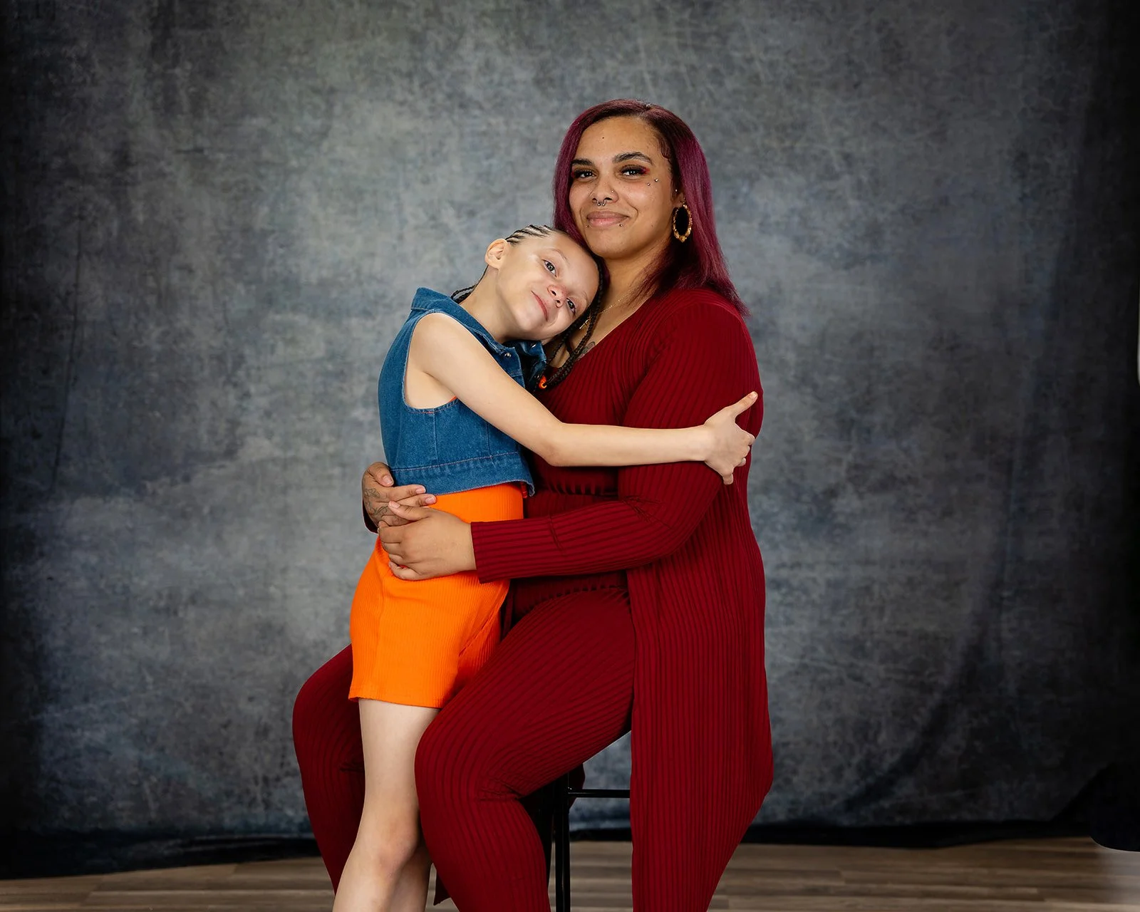 a daughter and mother pose together for a studio portrait