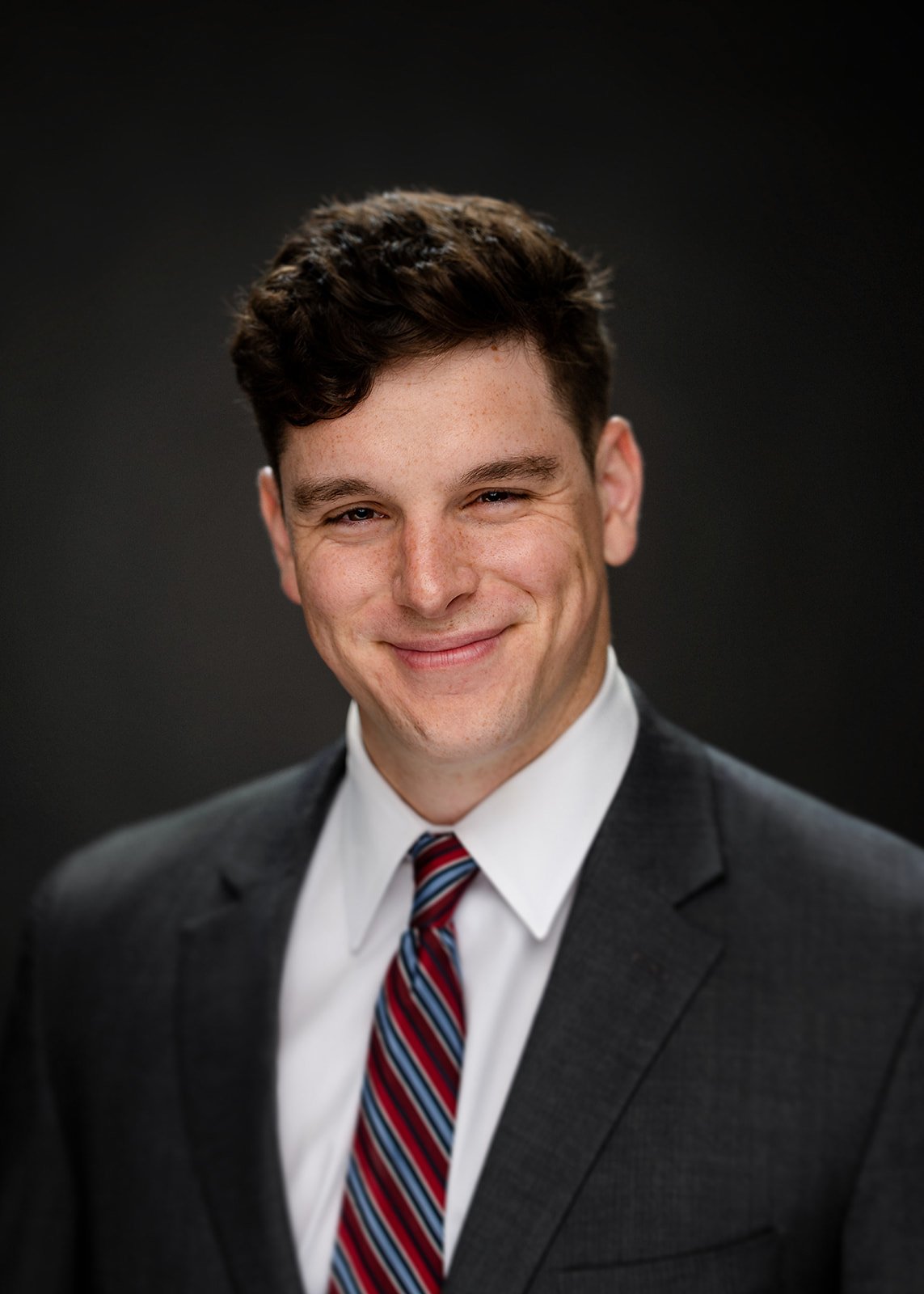 headshot of young man posing for a studio portrait