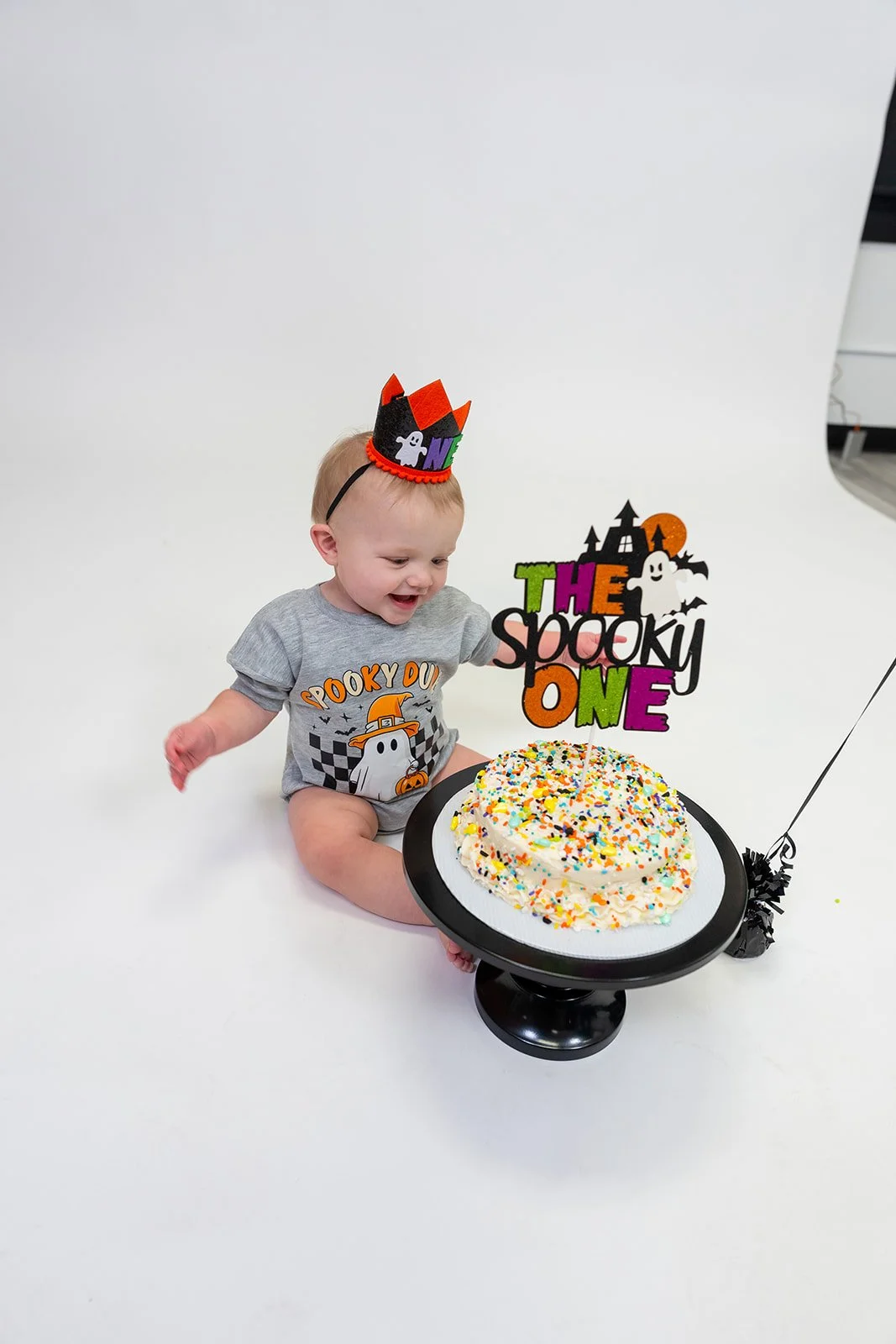 a one year old smashes his cake for a birthday photo shoot