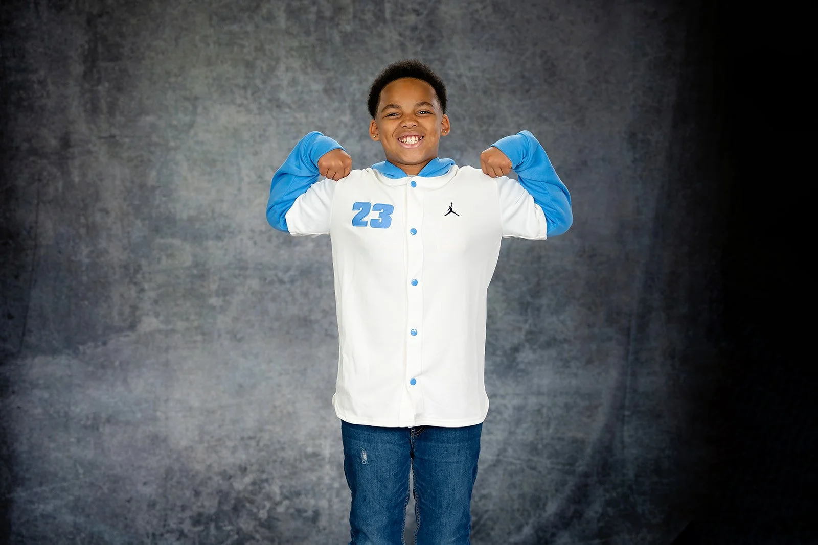 a young man flexes his muscles for a studio portrait