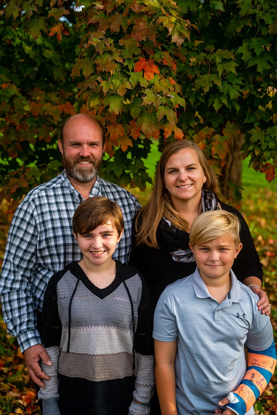 a husband and wife smile with their children
