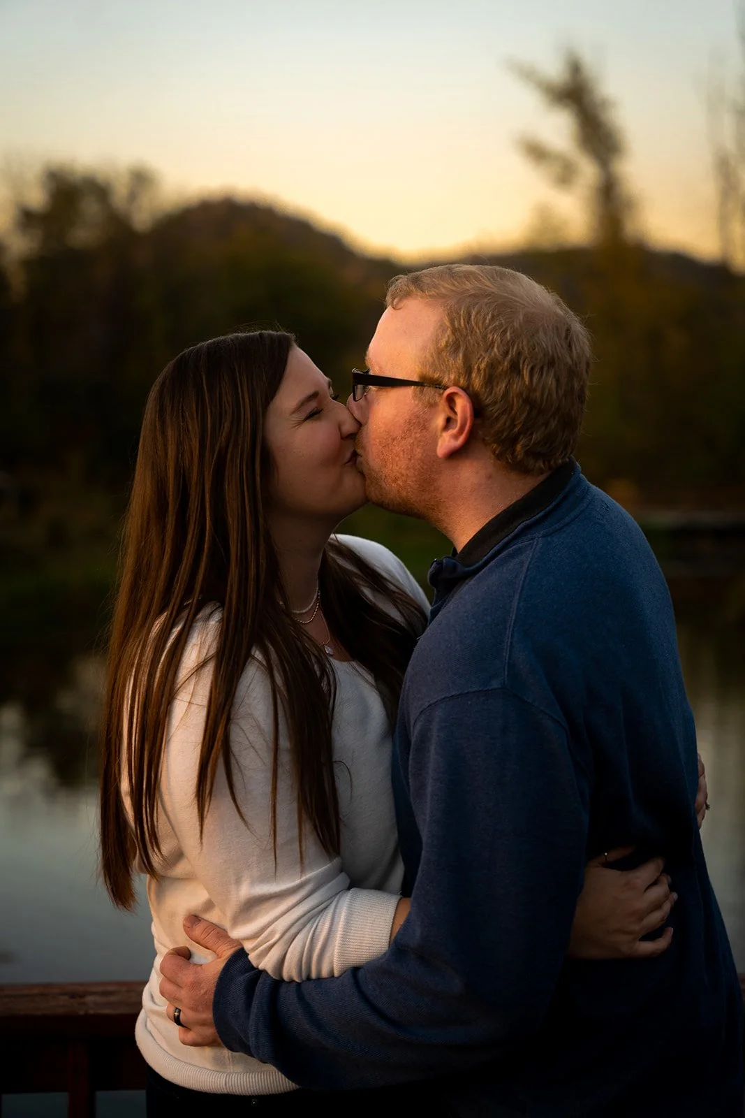 A young couple kisses for the camera