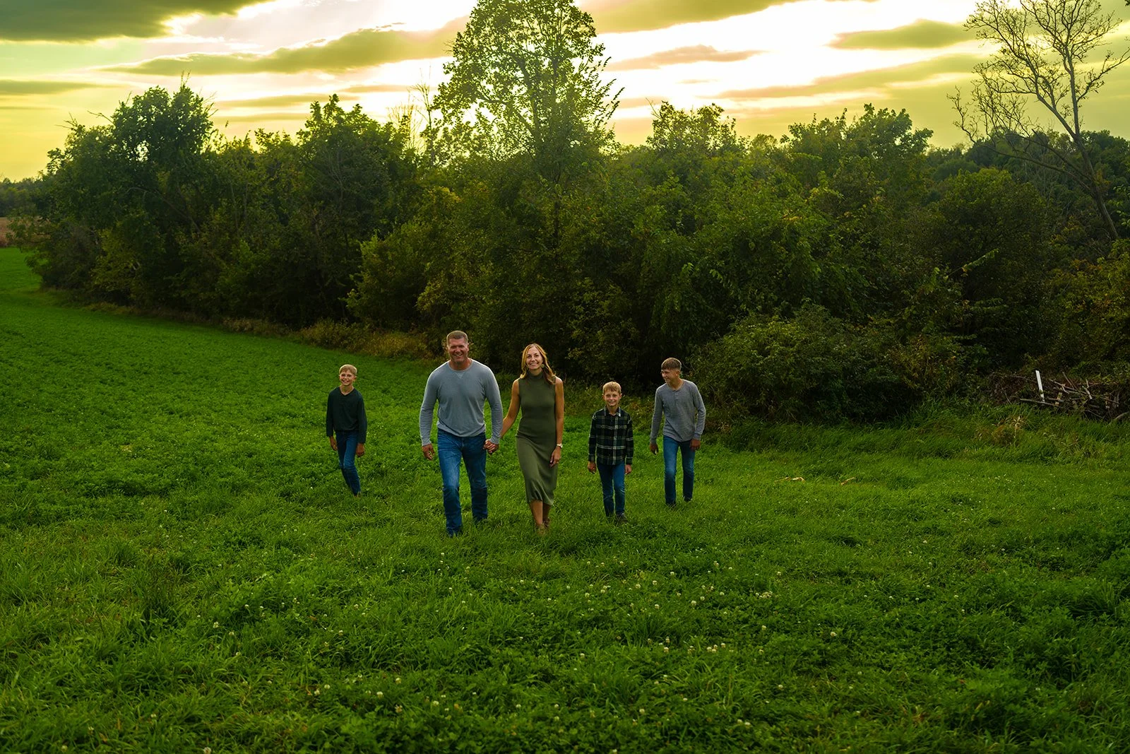 a family of five walk across a field