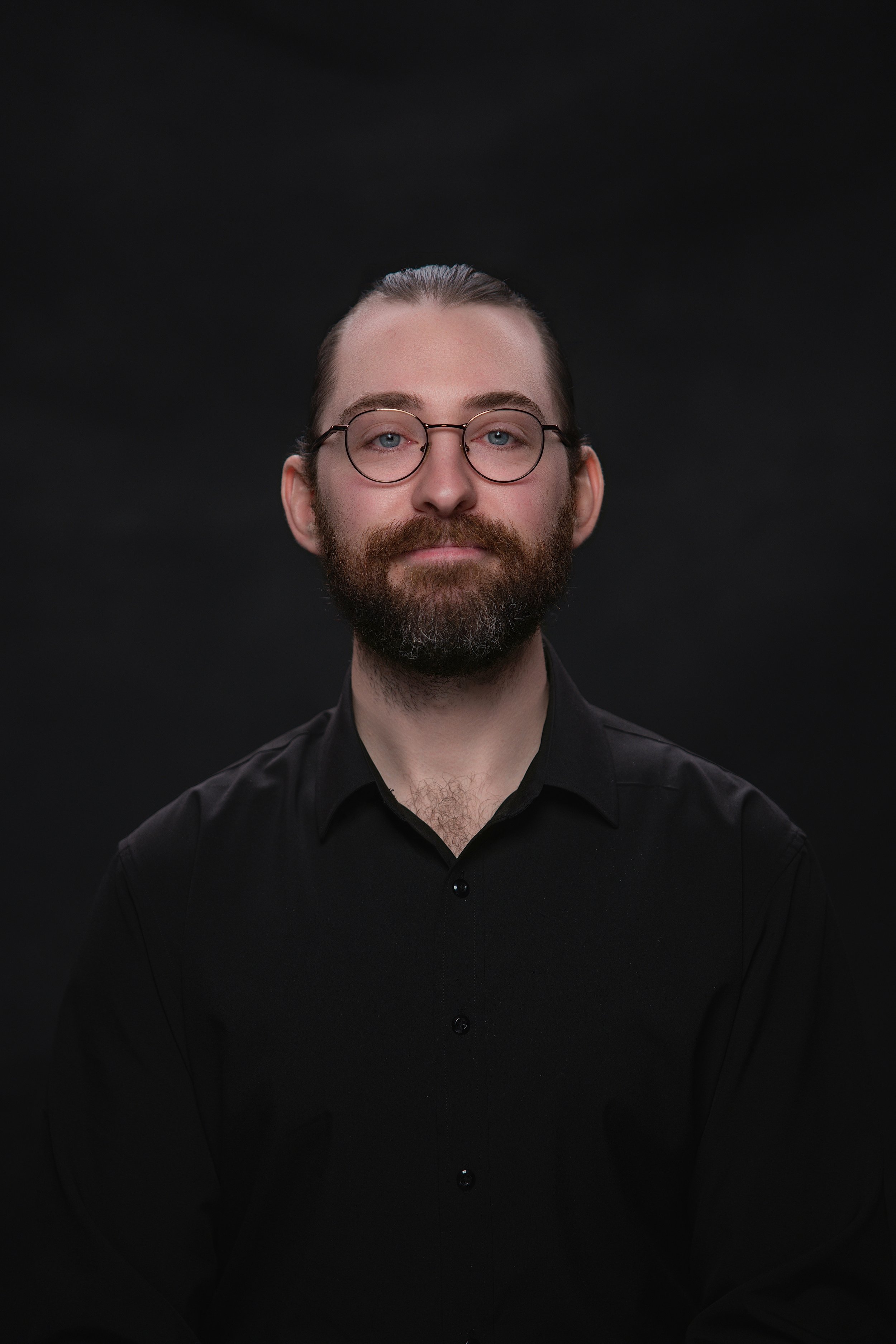 photo of a young man posing for a portrait in a studio headshot