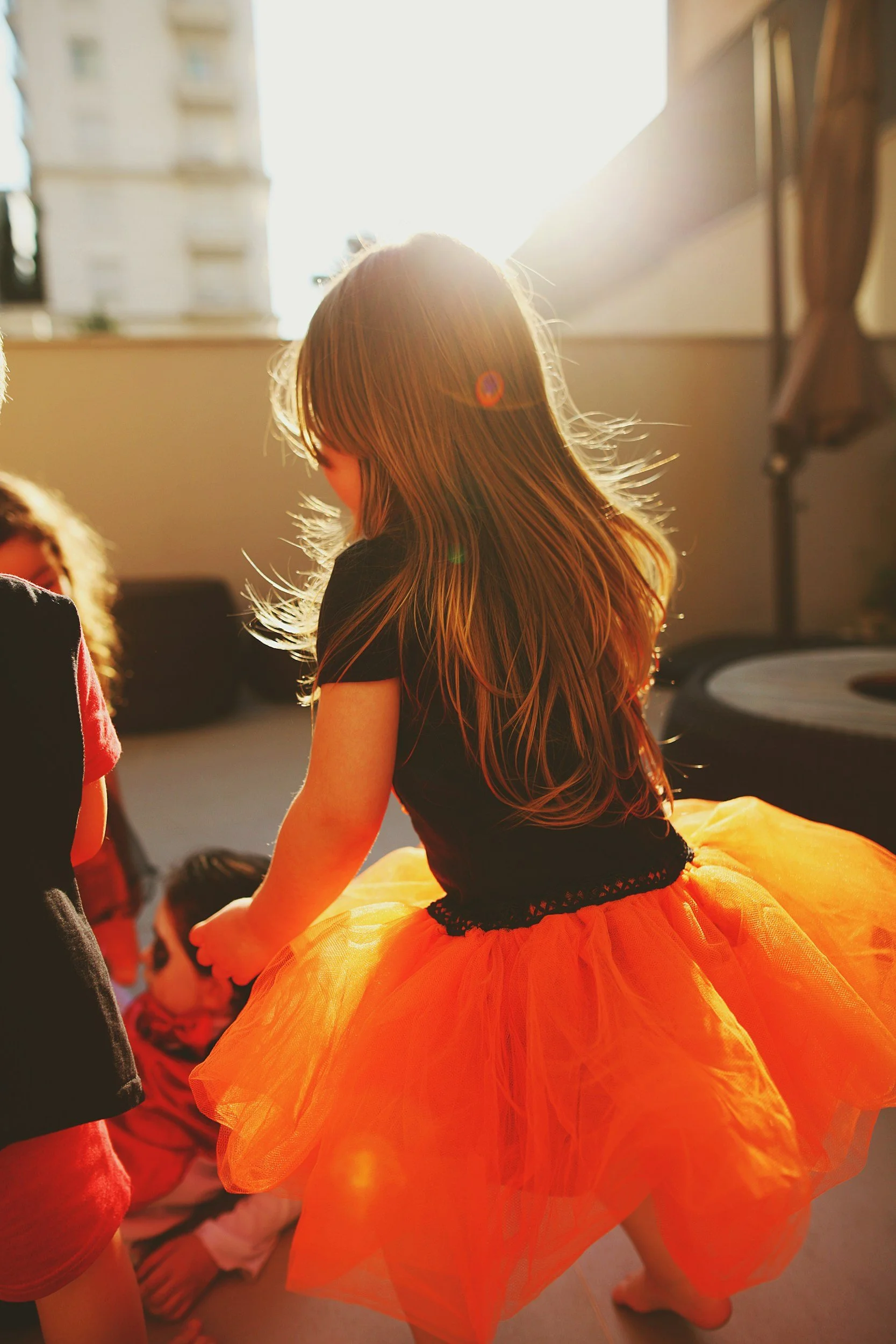 A child wearing a tutu in the sun during a creative movement class.