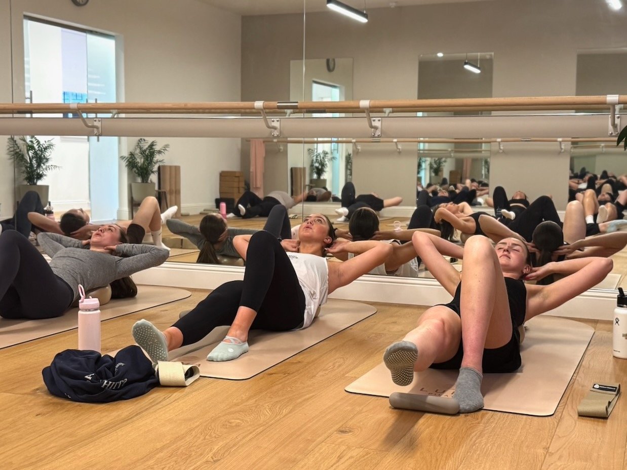 Clients performing core exercises in a Mat Pilates class at Luma Pilates in Edinburgh
