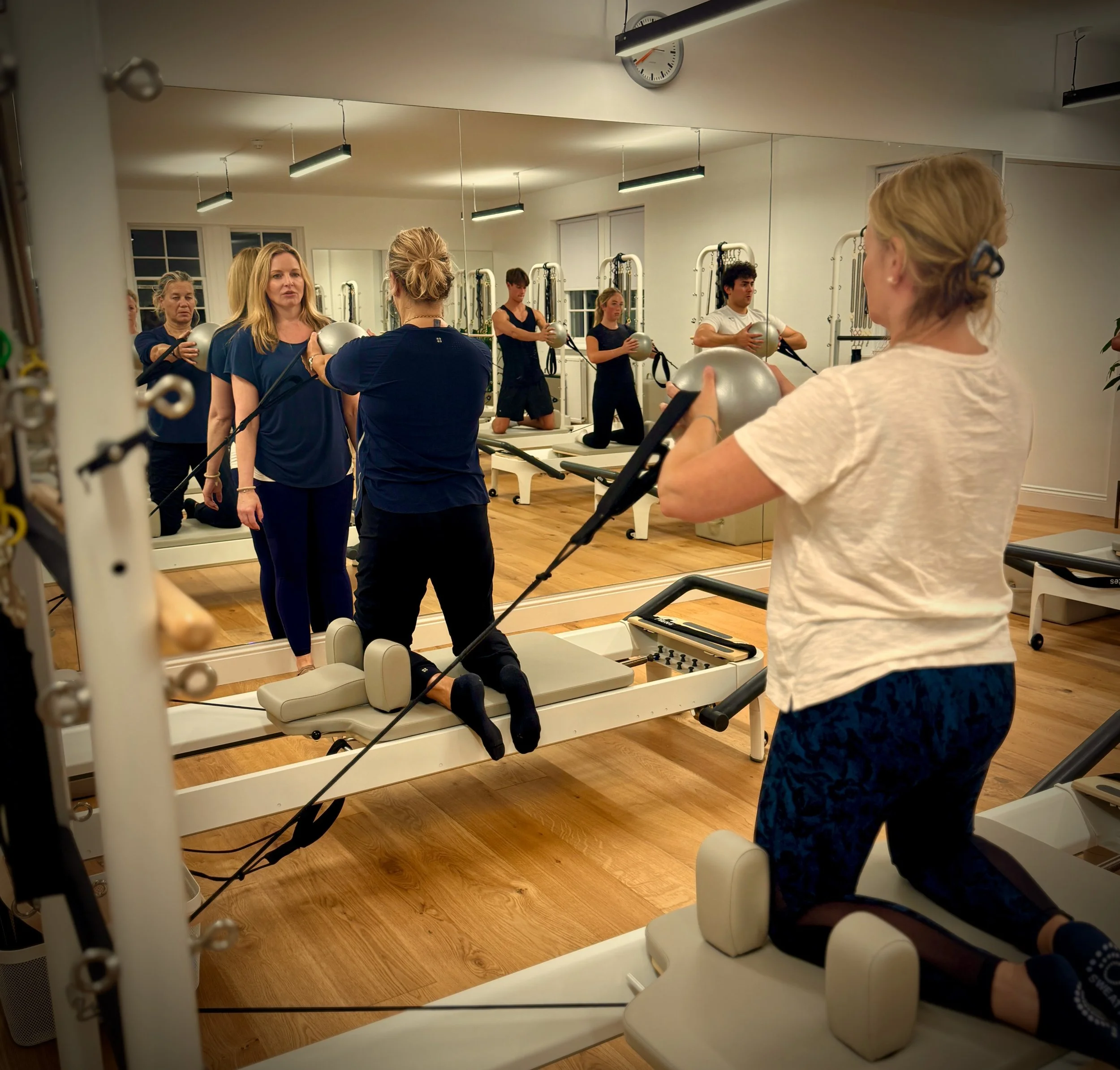 People taking part in a Reformer Pilates class at Luma Pilates in Edinburgh