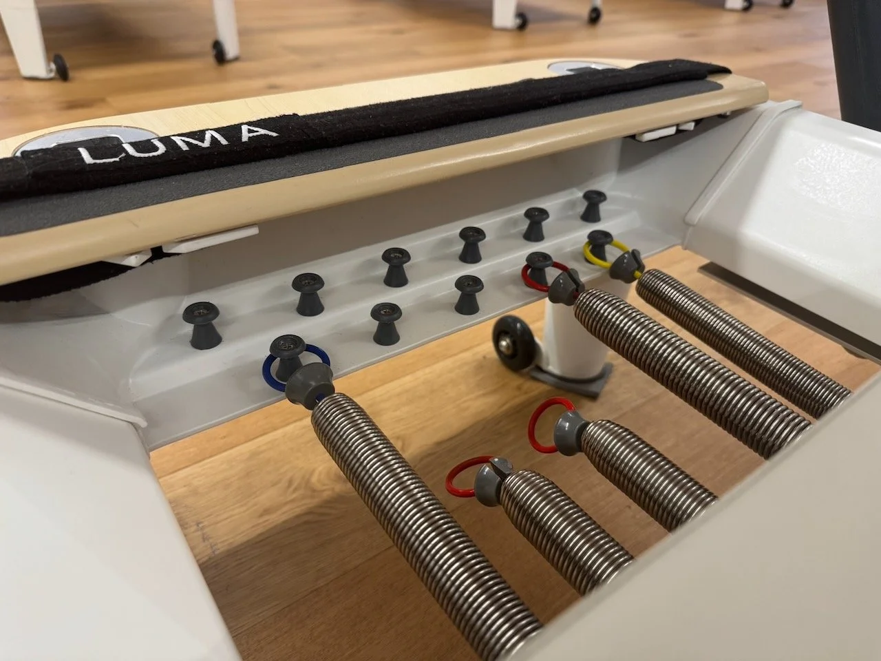Close-up of colour-coded Reformer springs beneath the carriage for different class levels and exercise intensity at Luma Pilates, Edinburgh