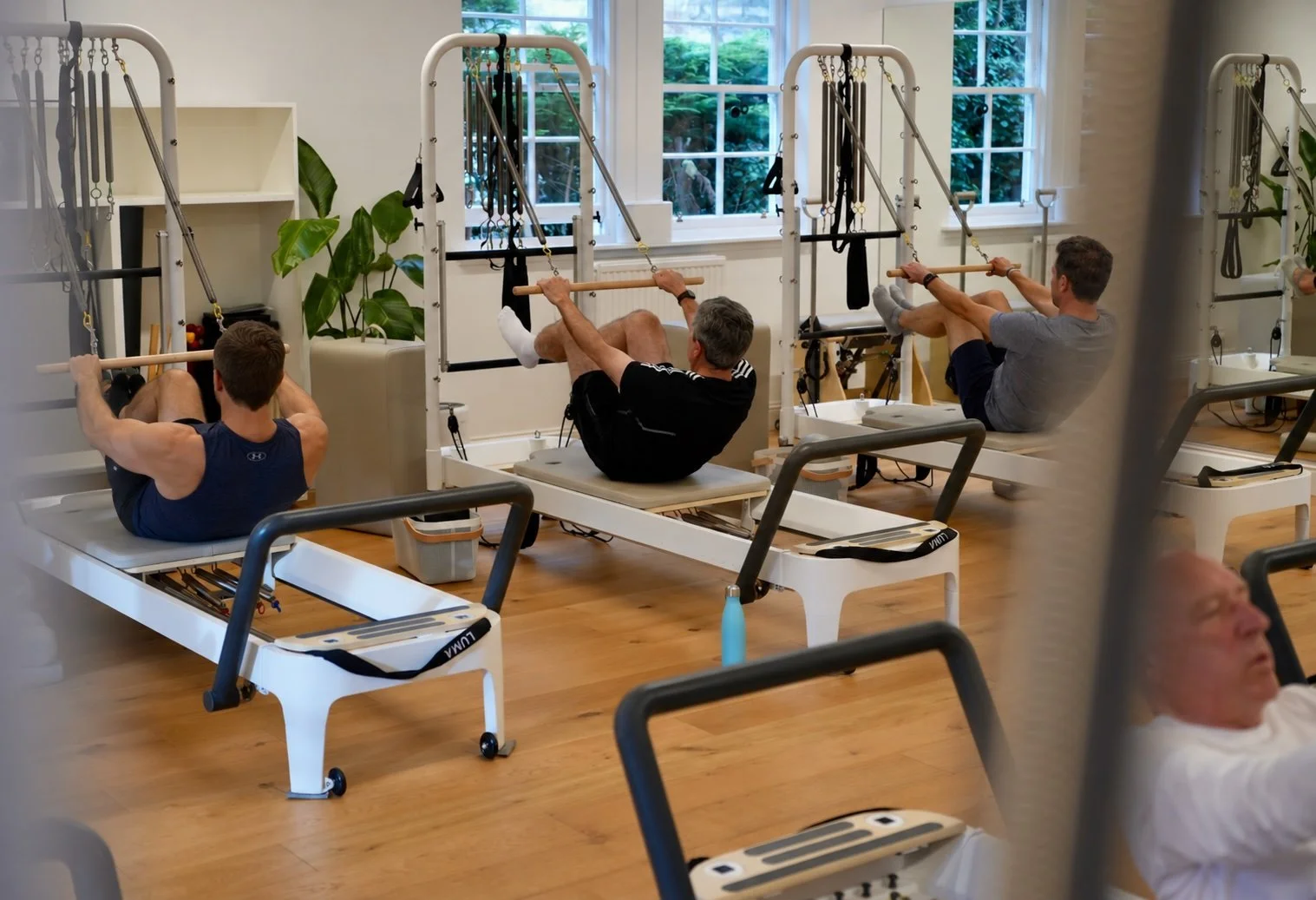 A men's Reformer Pilates class at Luma Pilates, Edinburgh