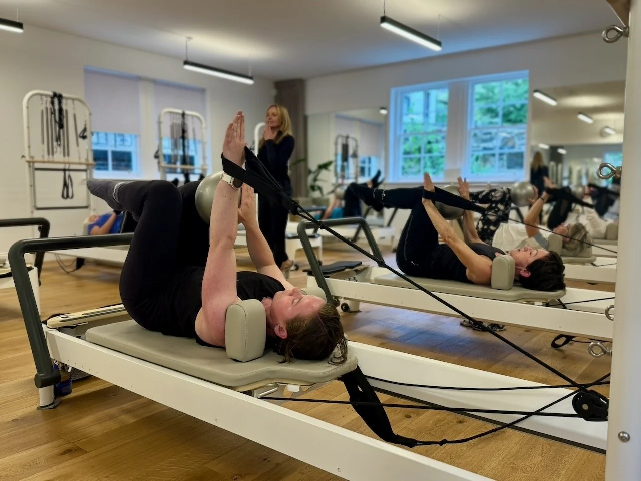 Clients working hip flexor and glute sequences on the Reformer at Luma Pilates Edinburgh. The muscles runners neglect most