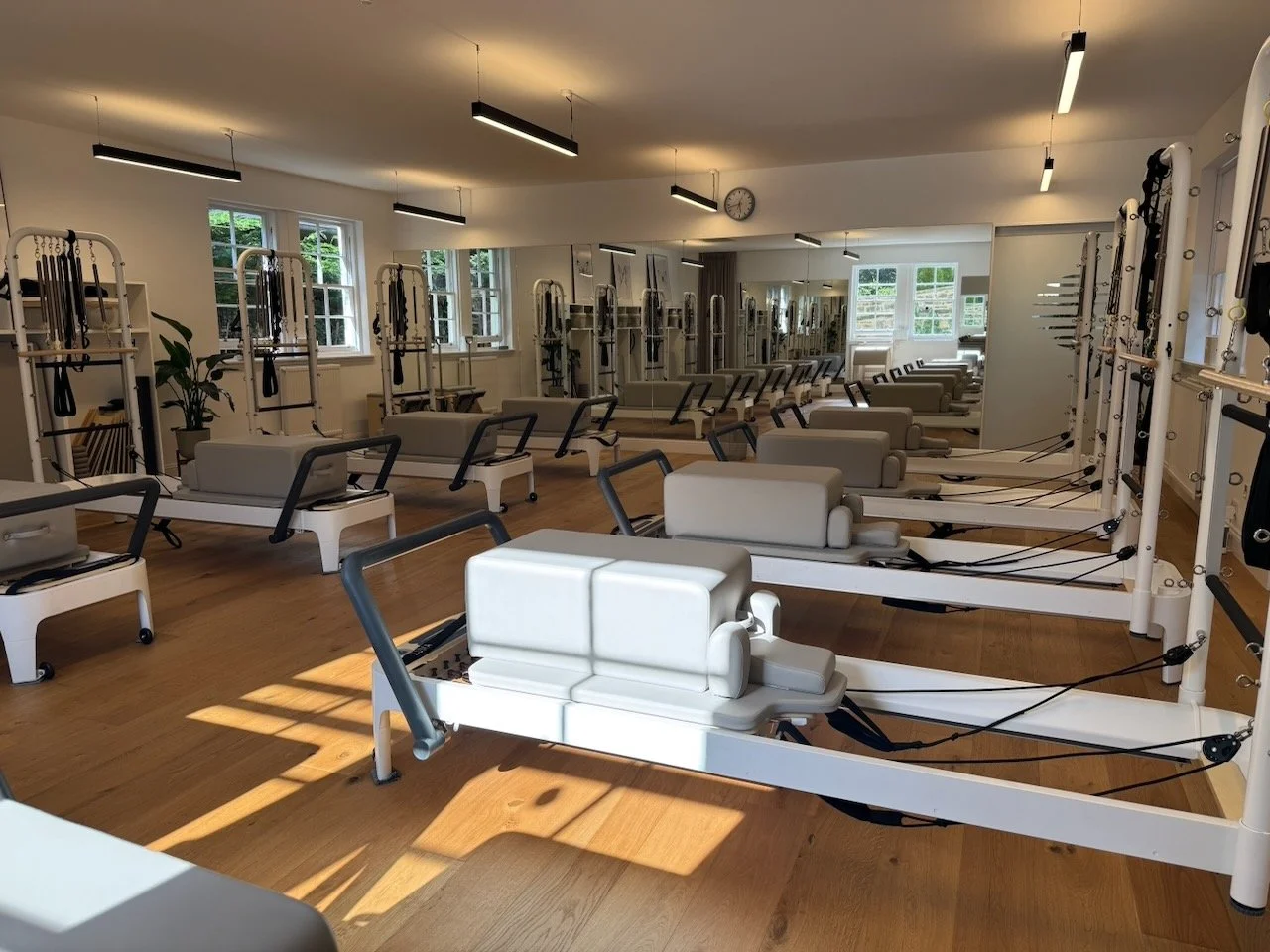 Studio A at Luma Pilates, Edinburgh. 10 Reformers with Tower, bathed in sunlight.