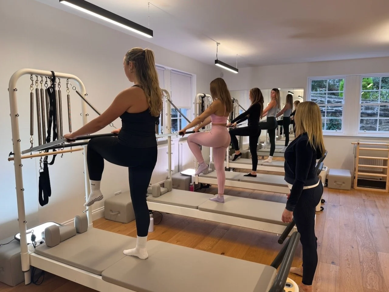 Clients working on balance and spinal alignment during a Tower class at Luma Pilates in Edinburgh's New Town