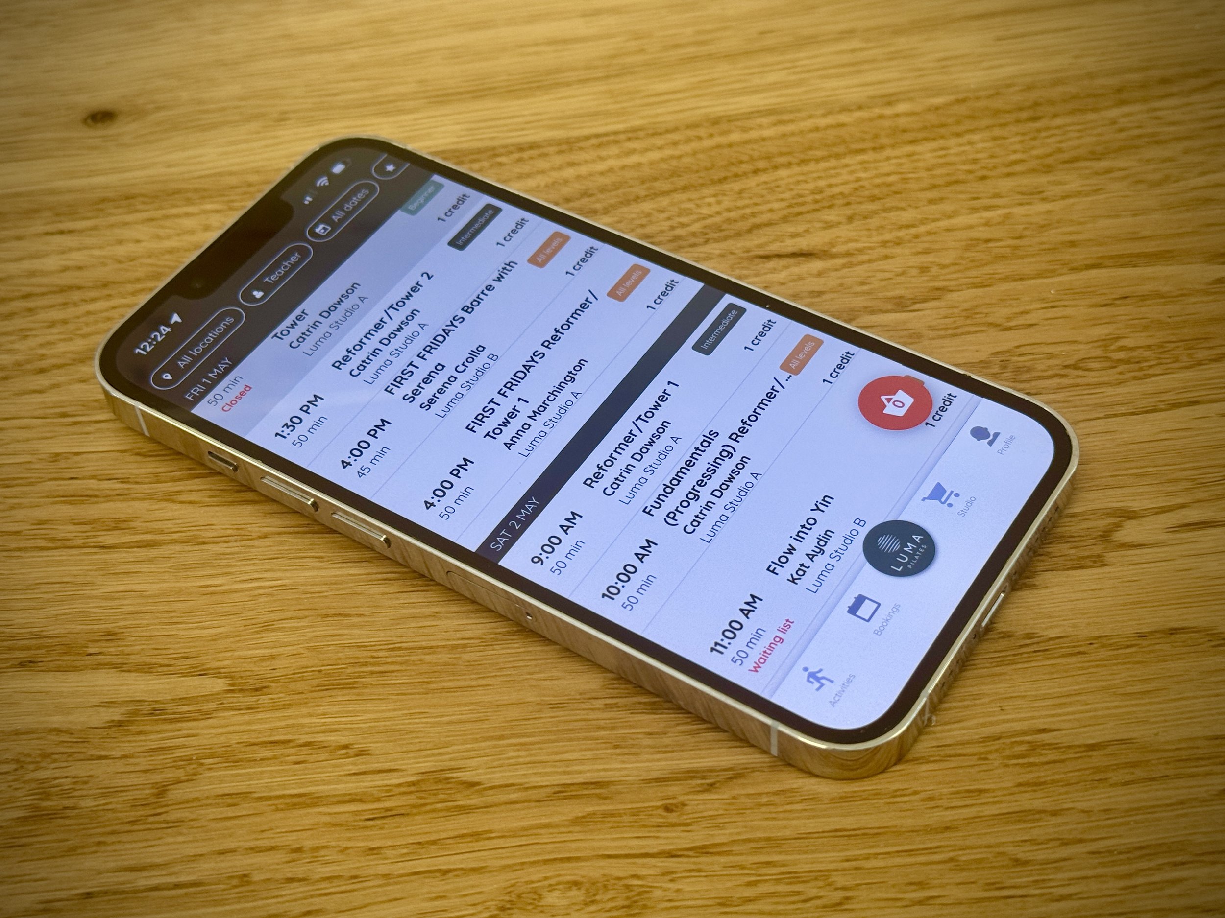 Smartphone displaying a timetable or schedule app, placed on a wooden surface.