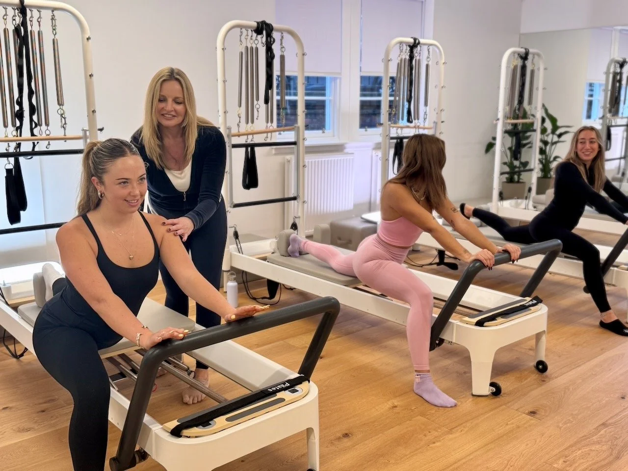 Lucia Poulter cueing a client during a hip flexor stretch on a Reformer at Luma Pilates in Edinburgh