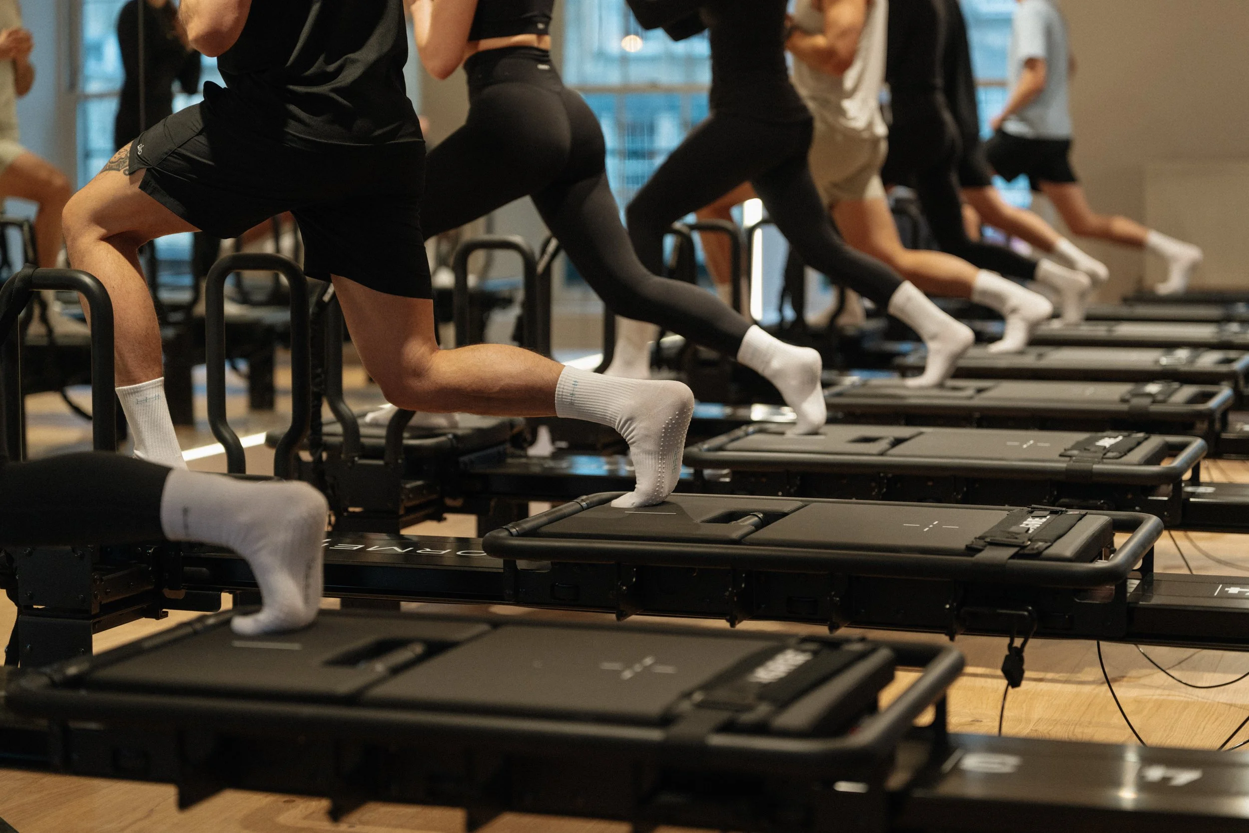 Close-up of clients in a lunge position on Minformer Pro machines during a Lagree class at Tallie Lagree Edinburgh