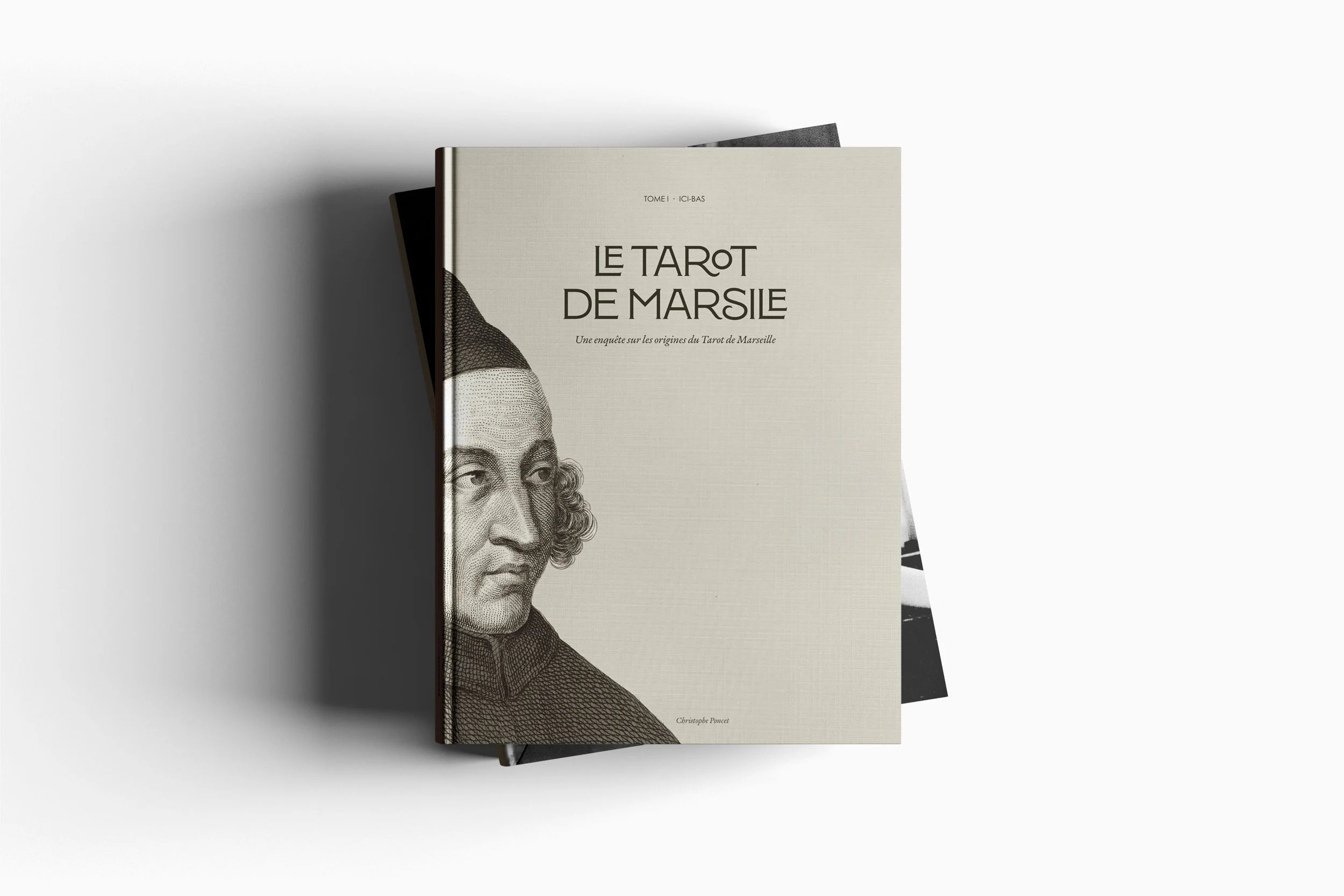 Deux livres empilés, dont la couverture du dessus représente un portrait d'un homme en noir et blanc et le titre "Le Tarot de Marseille".