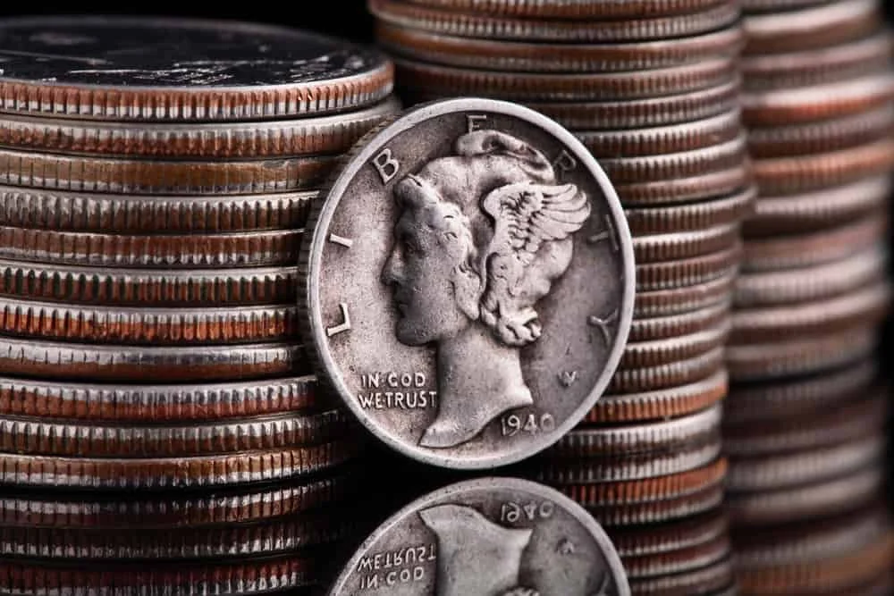 Stack of pennies with a close-up of a 1940 Mercury dime coin.