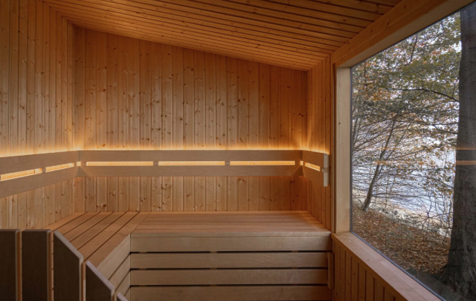 Other Fold Sauna Wood-paneled sauna room with a large window showing trees and outdoor scenery.