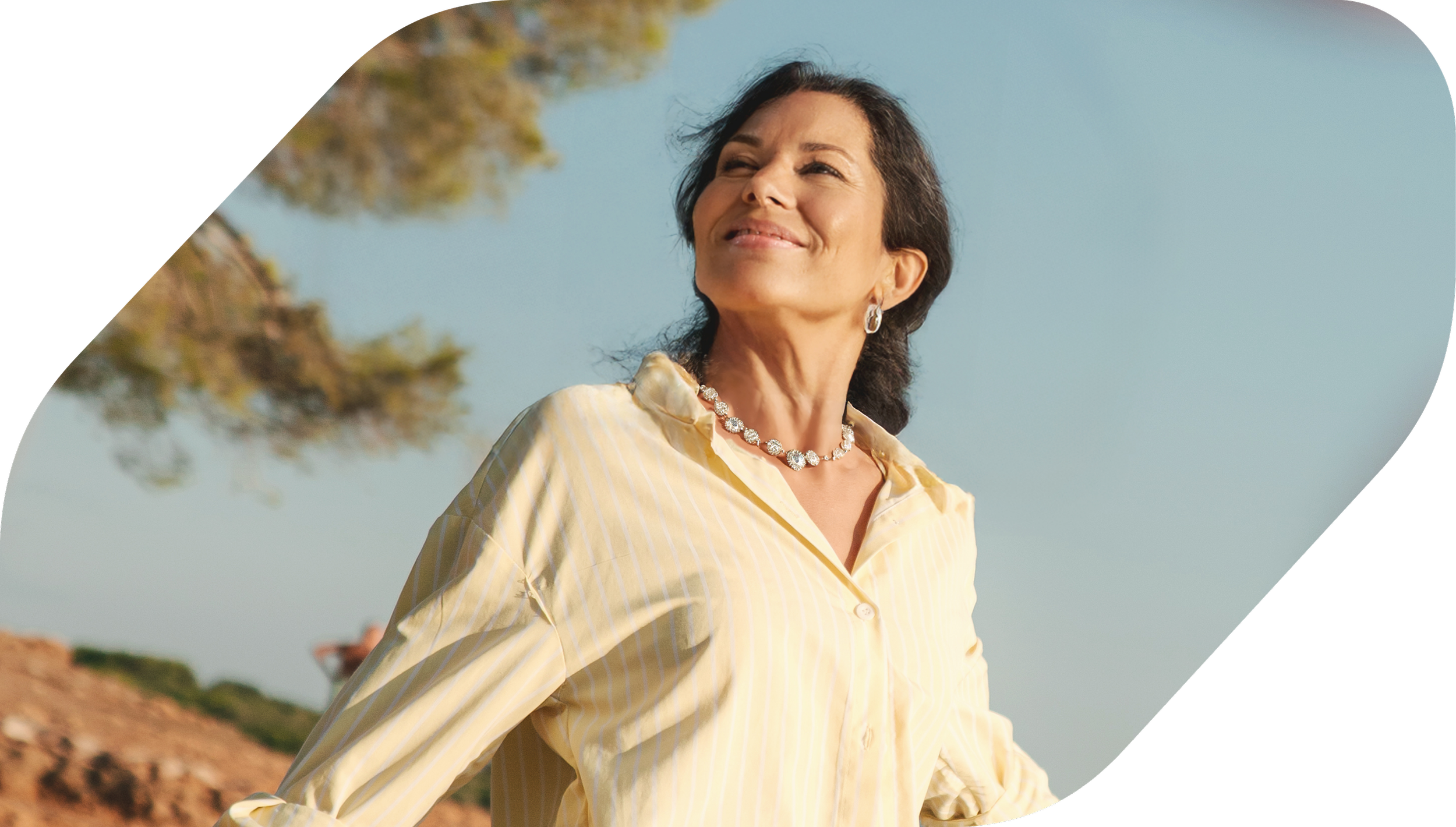 Woman outdoors smiling confidently under clear blue sky, symbolizing financial clarity and peace of mind.