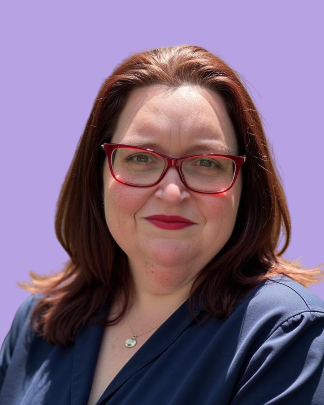 A woman with red hair, glasses, and red lipstick smiling against a lavender background.