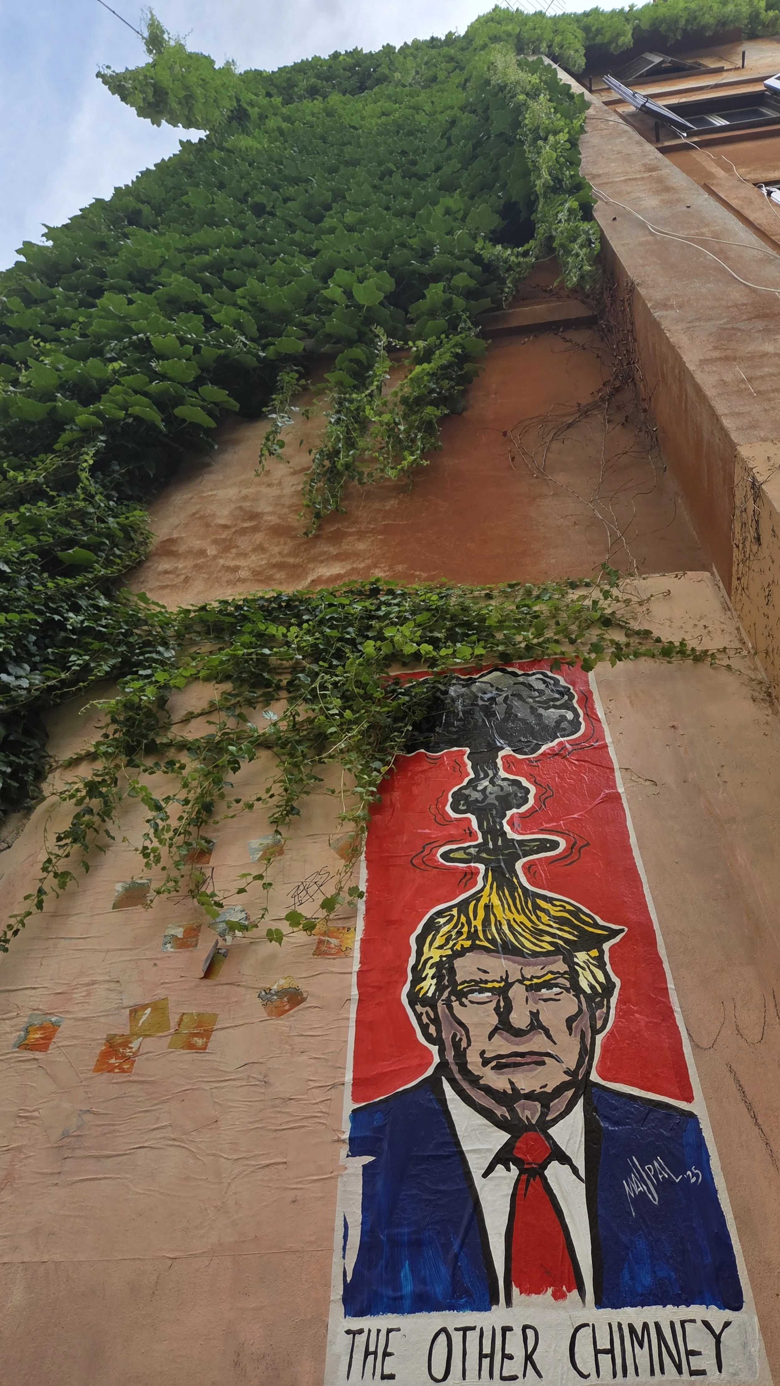 Straßenwandmit einem Graffiti von Donald Trump, der mit einer Atompilzwolke über seinem Kopf dargestellt ist, und dem Text "THE OTHER CHIMNEY".