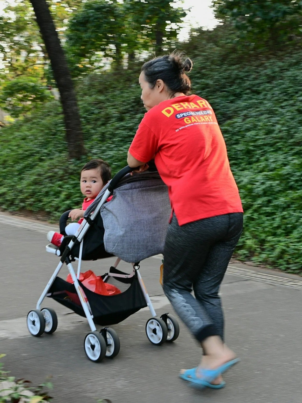 Parent with messy bun pushing stroller with toddler