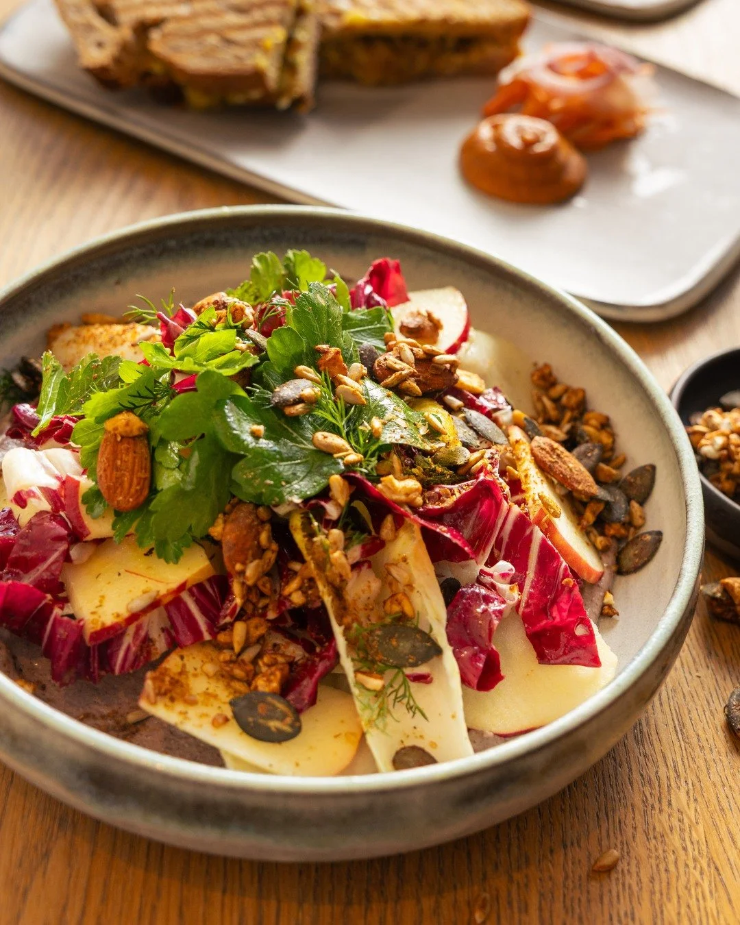 Wer sagt, dass Winter-Salate langweilig sein m&uuml;ssen?

Unser Winter-Power-Salat bringt Tiefe, Crunch und W&auml;rme auf den Teller:
Chicor&eacute;e &amp; roter Radicchio auf cremigem schwarzen-Bohnen-Hummus, dazu herzhafte N&uuml;sse, frischer Ap
