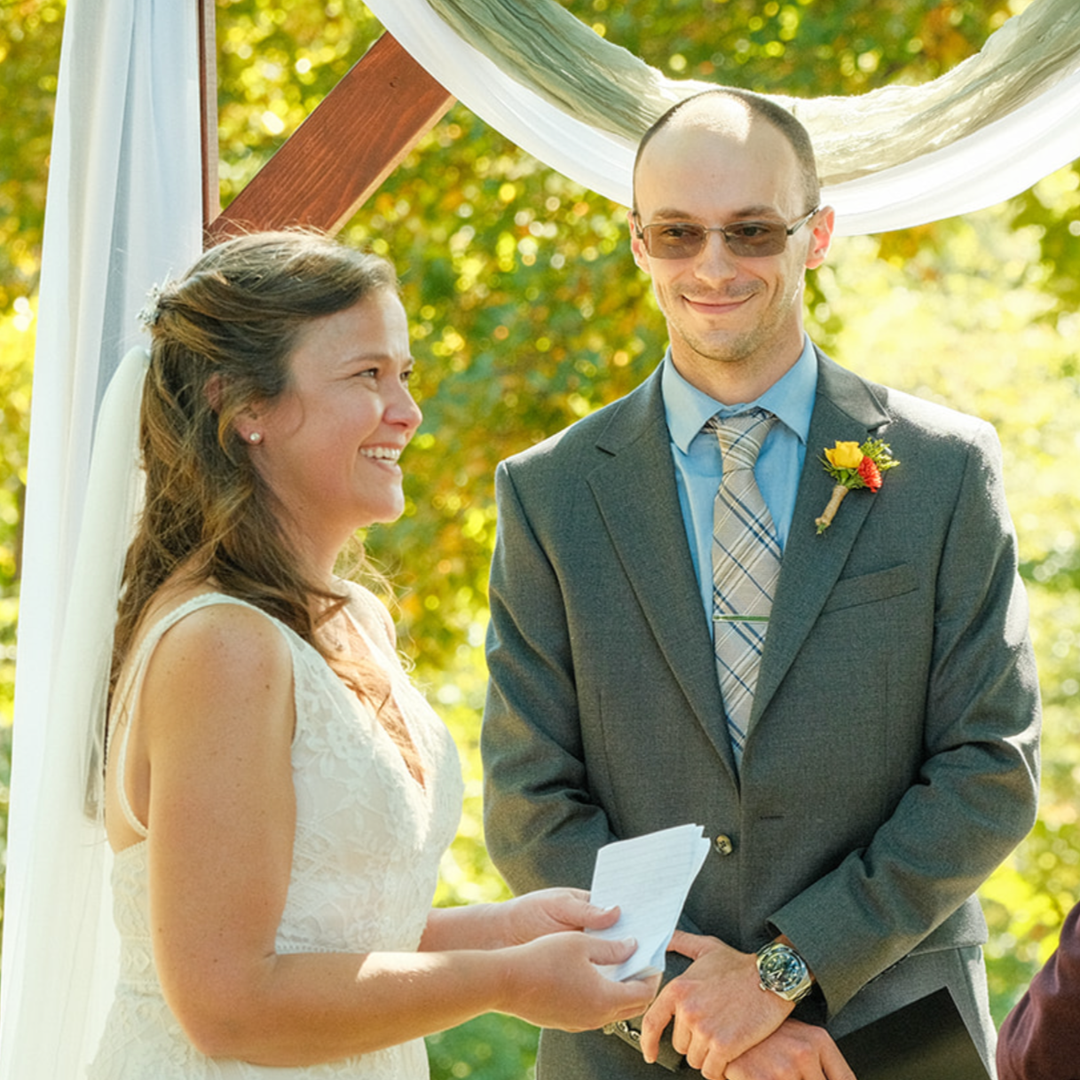 Bride exchanging vows at the altar during the wedding ceremony, with the officiant standing beside her.
