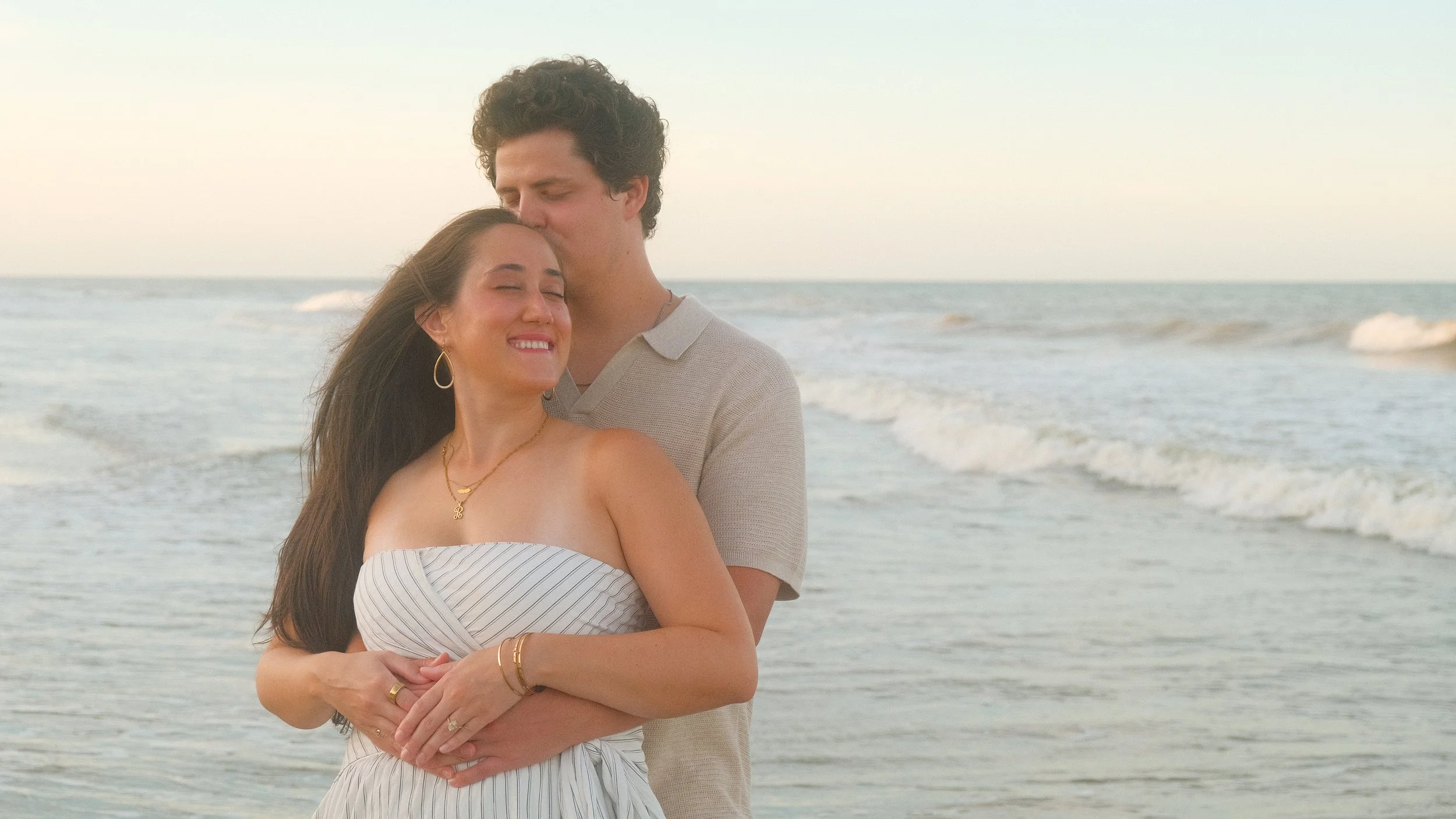 Portrait of a couple smiling in front of the beach