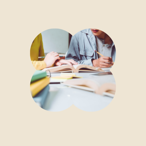 A person working and reading books at a table.