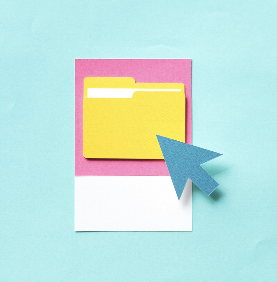 Yellow folder with a white tab on pink paper, with a blue paper cursor pointing at it, against a light blue background.