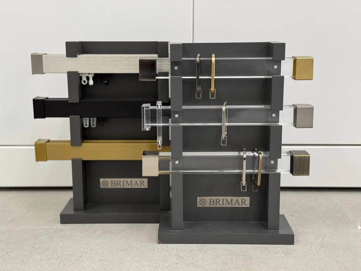 drapery hardware display with curtain rods, brackets, and finishes