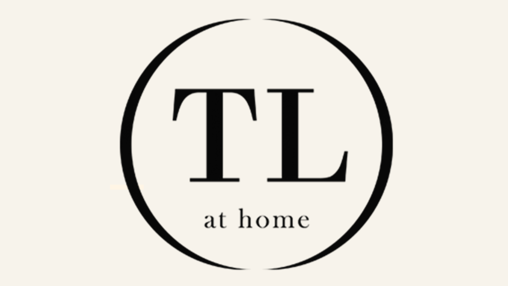 Elegant logo with the initials T and L inside a circular outline and the words 'at home' beneath.