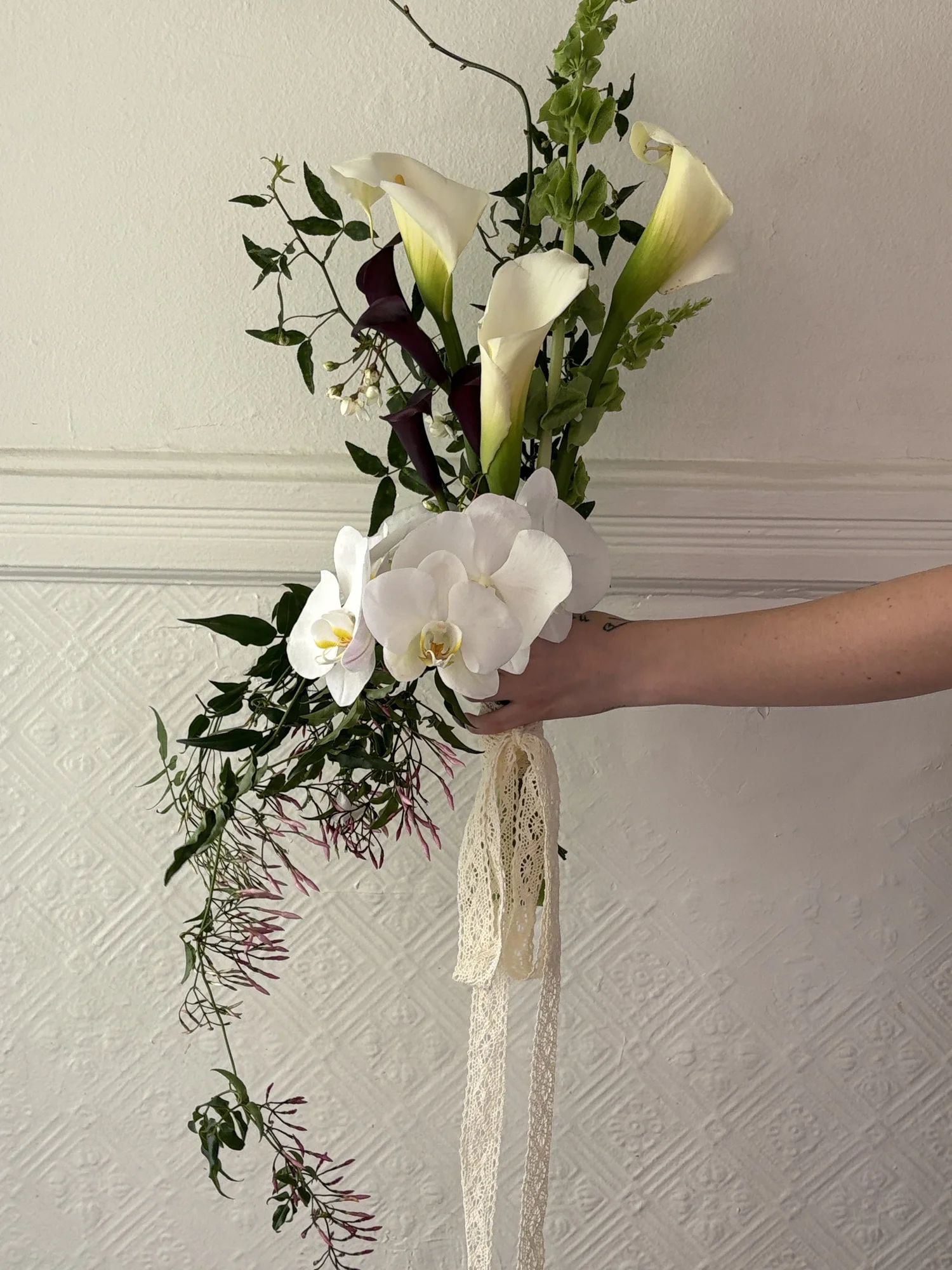 Calla lily and orchid bridal bouquet tied with lace ribbon