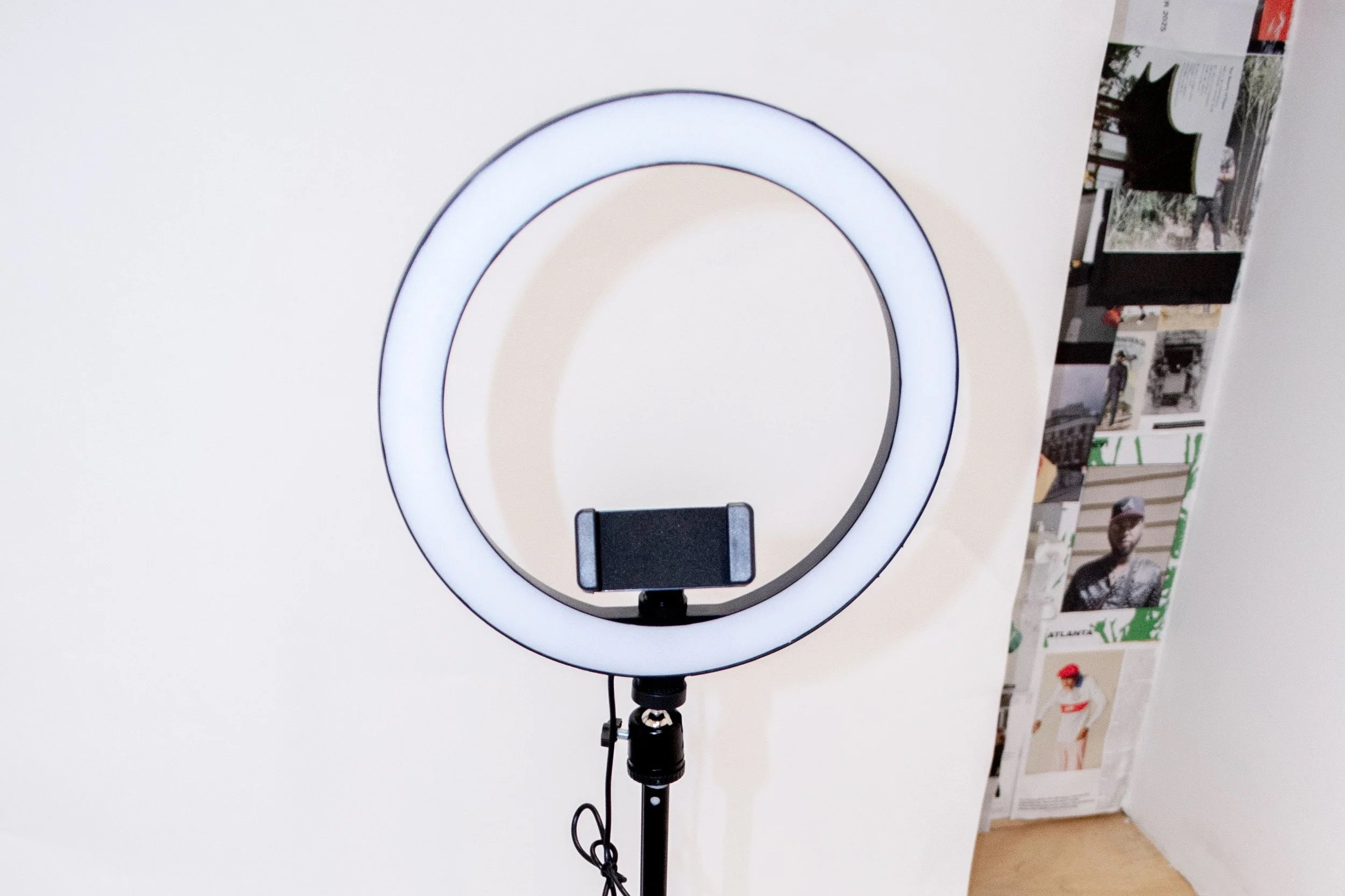 A mountain landscape showing snow-capped peaks in the background and a modern building on a grassy hillside in the foreground.