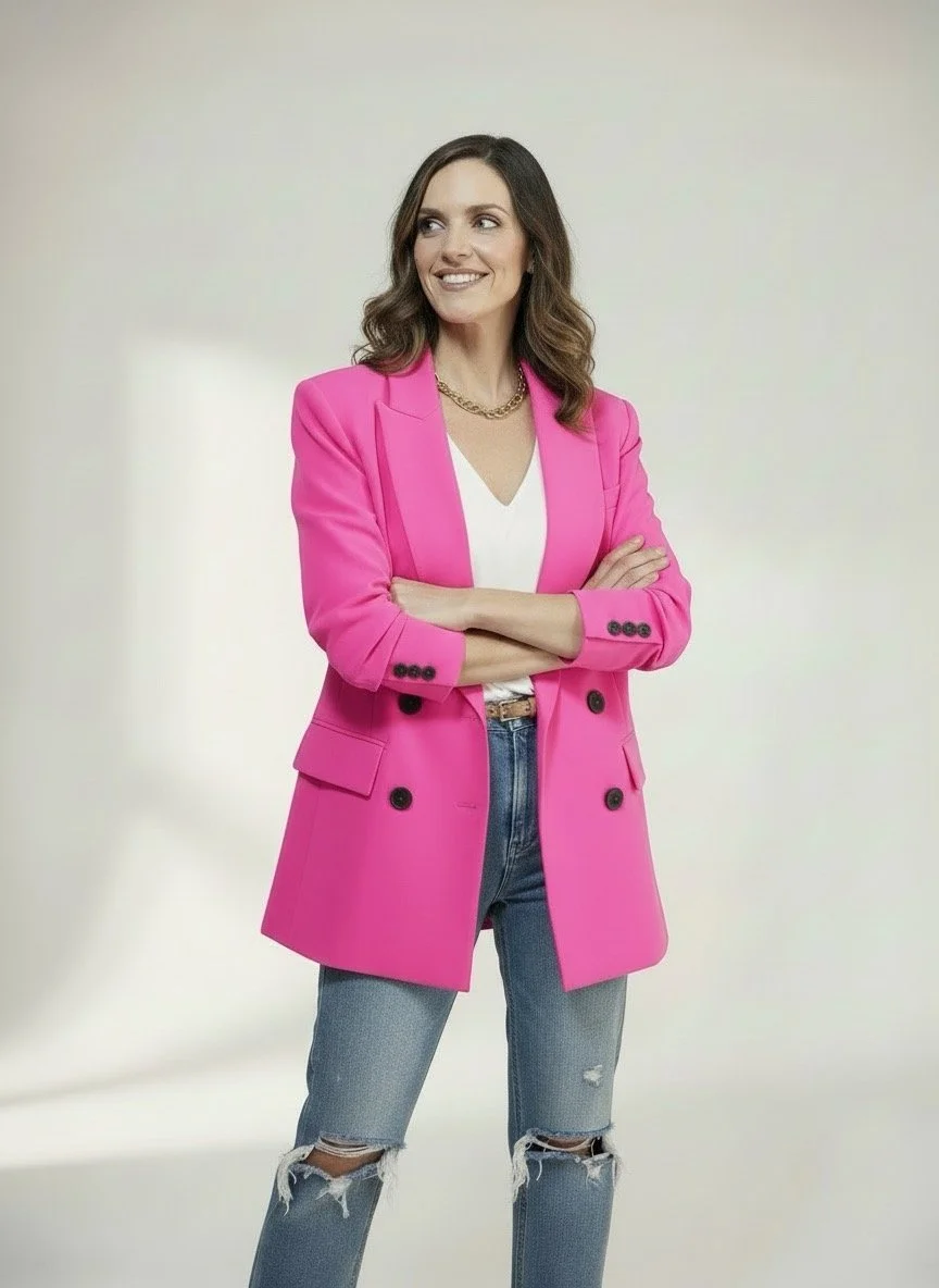 Livi smiles while crossing her arms and looking towards her right.