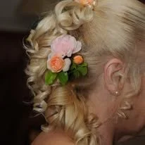 Coiffure de femme avec des fleurs, cheveux blonds et bouclés, vue de profil