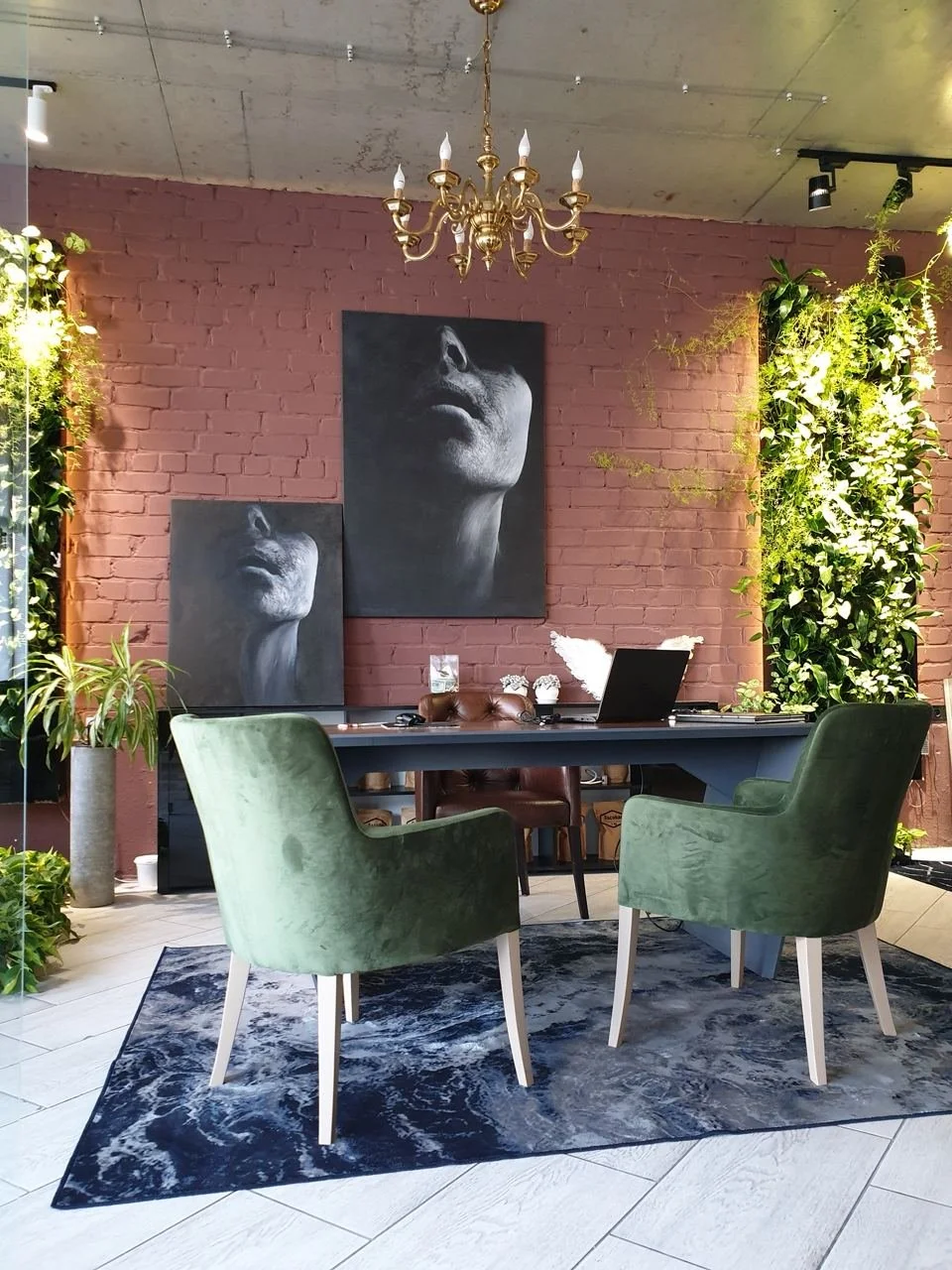 A cozy room with a colorful striped rug on wooden floors, a white bookshelf with books and decor, a black office chair with a green cushion, a window with trees outside, and a white radiator beneath the window.
